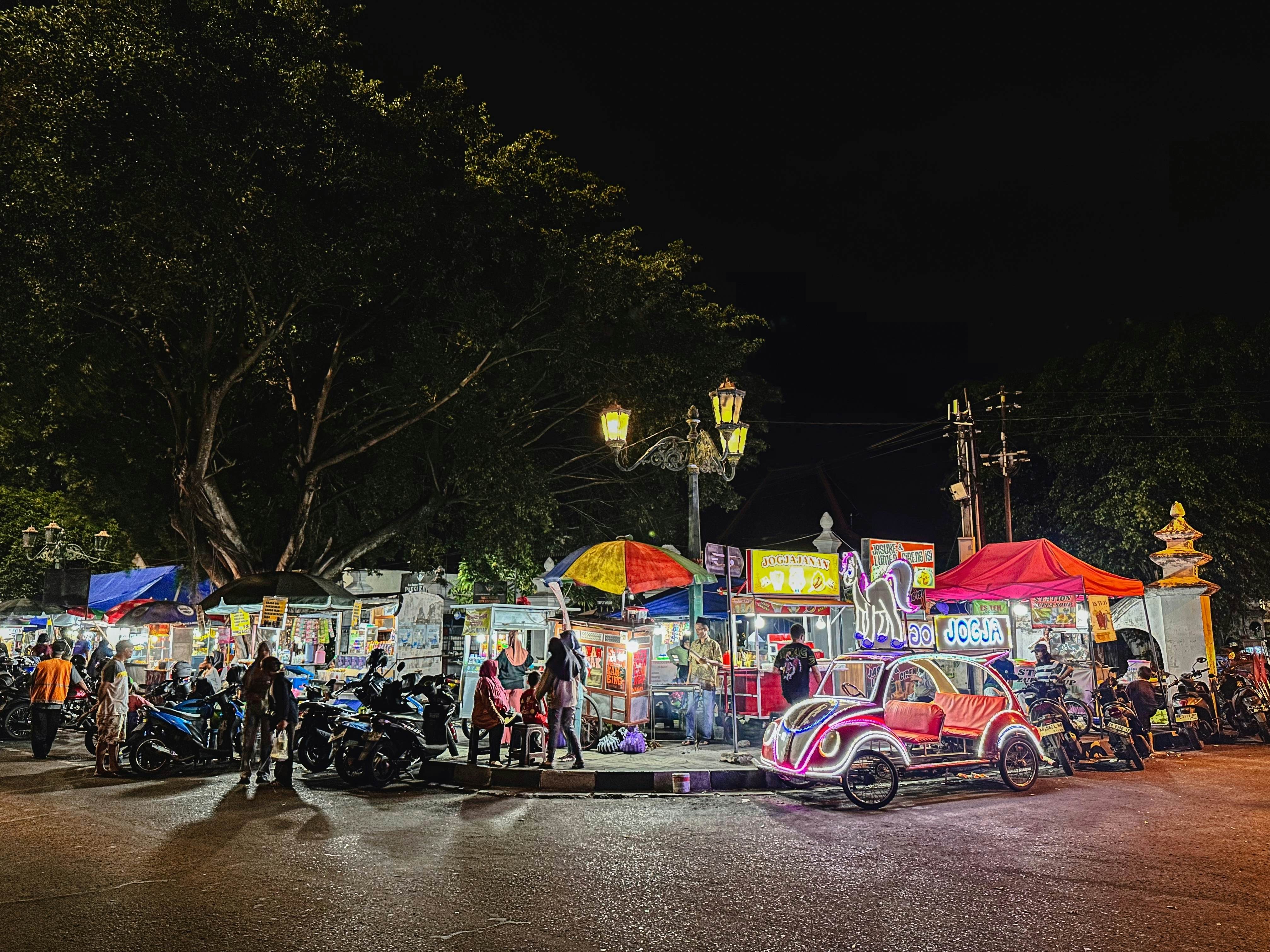 Street food stalls and pedal cars at Alun-Alun Kidul in Yogyakarta, Indonesia.