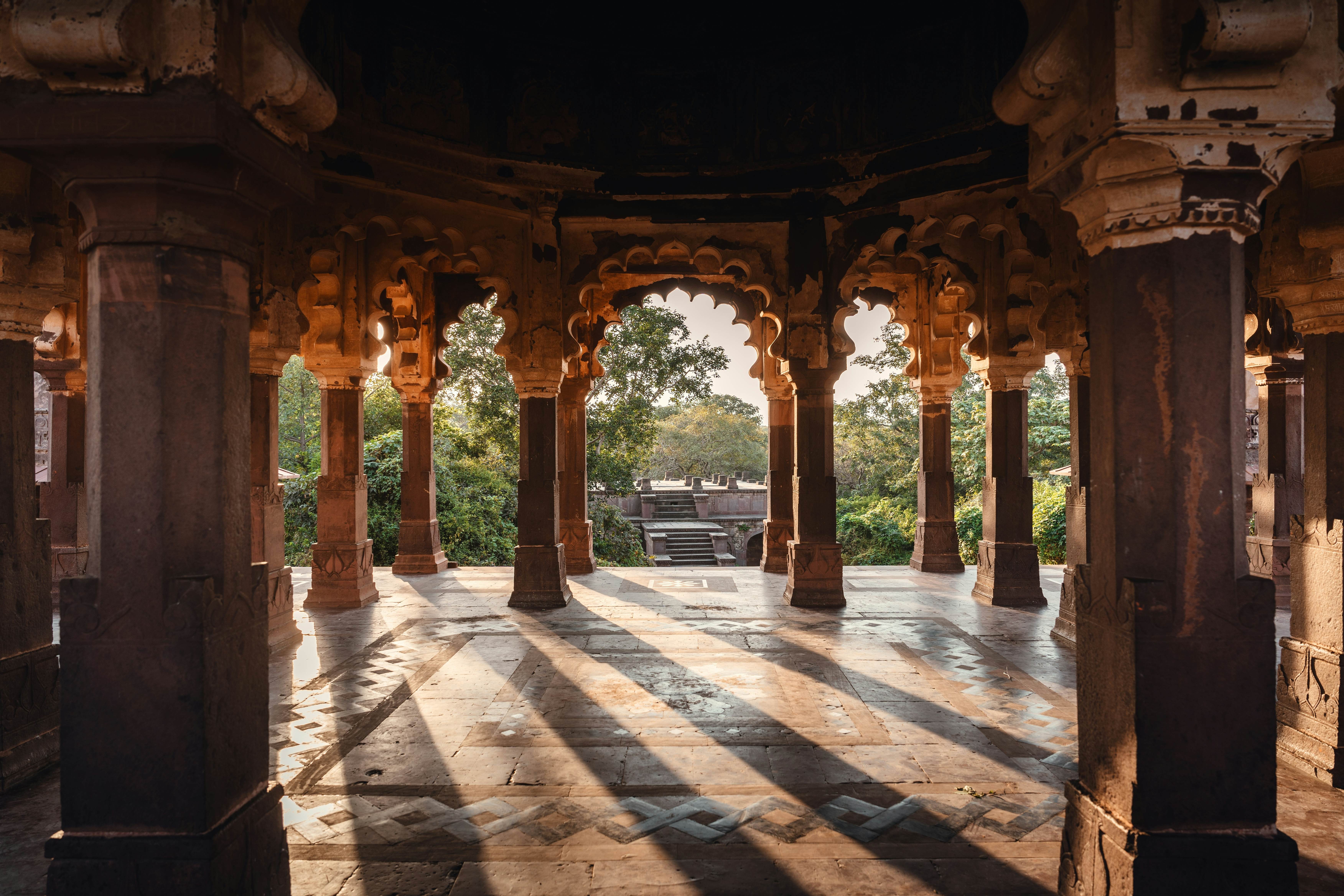 Shadows of columns cast over the stone floor of a fort building in the jungle