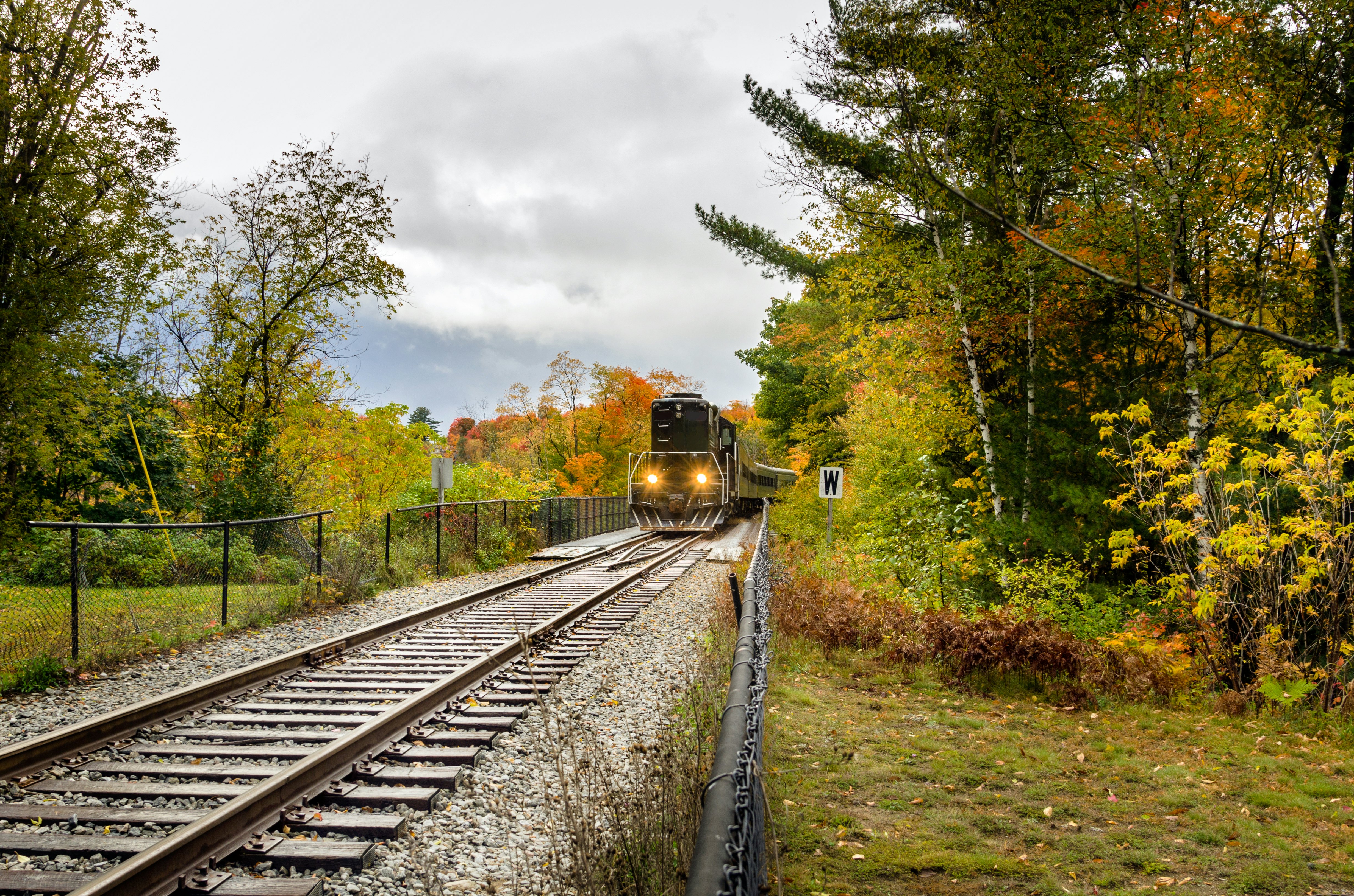 A large train engine coming down the tracks on a gloomy day.