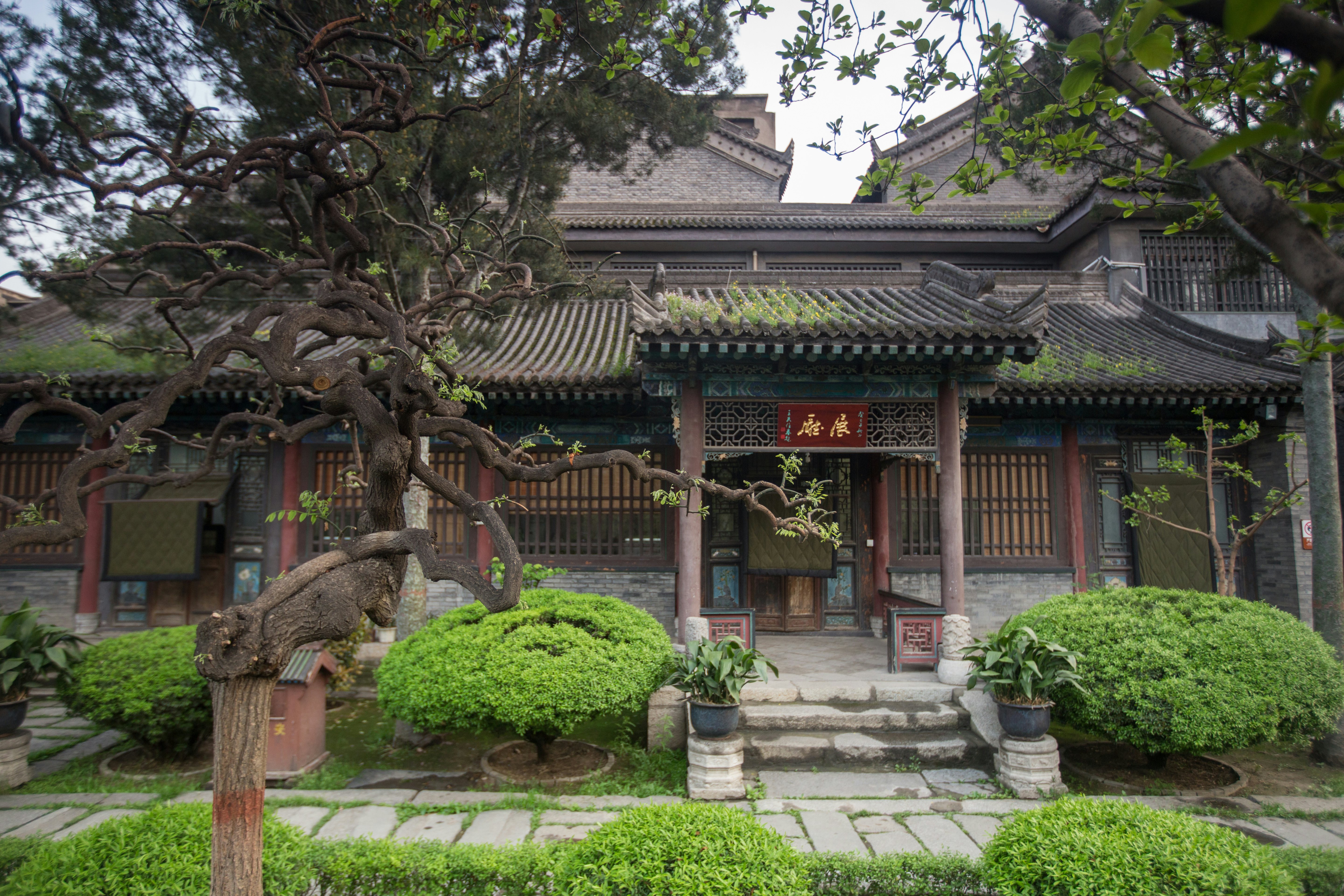 A small ancient building in neat gardens.