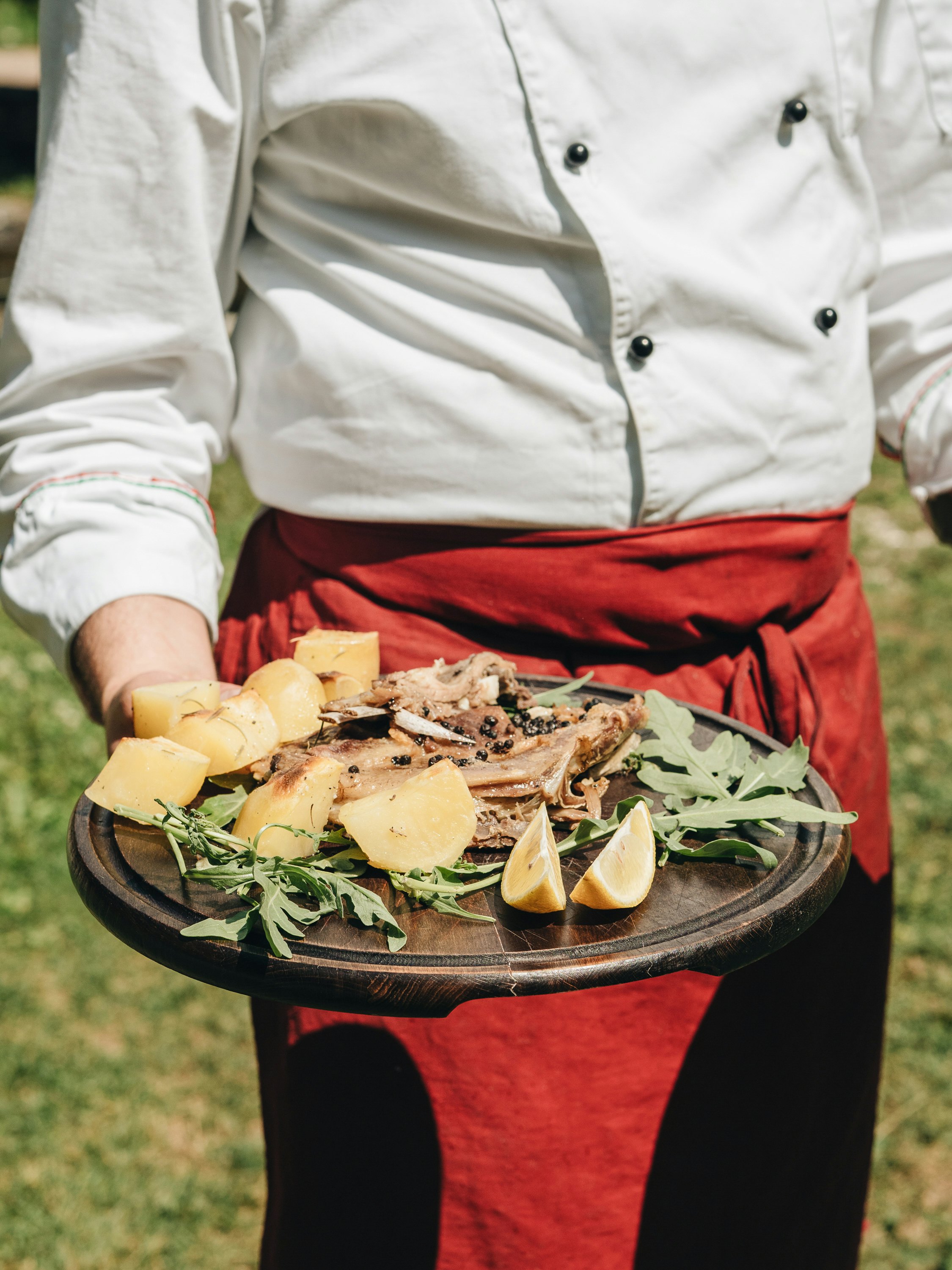 Man holds a plate with meat and potatoes and lemon -- shot with OLYMPUS DIGITAL CAMERA for Best in Travel 2023 Albania