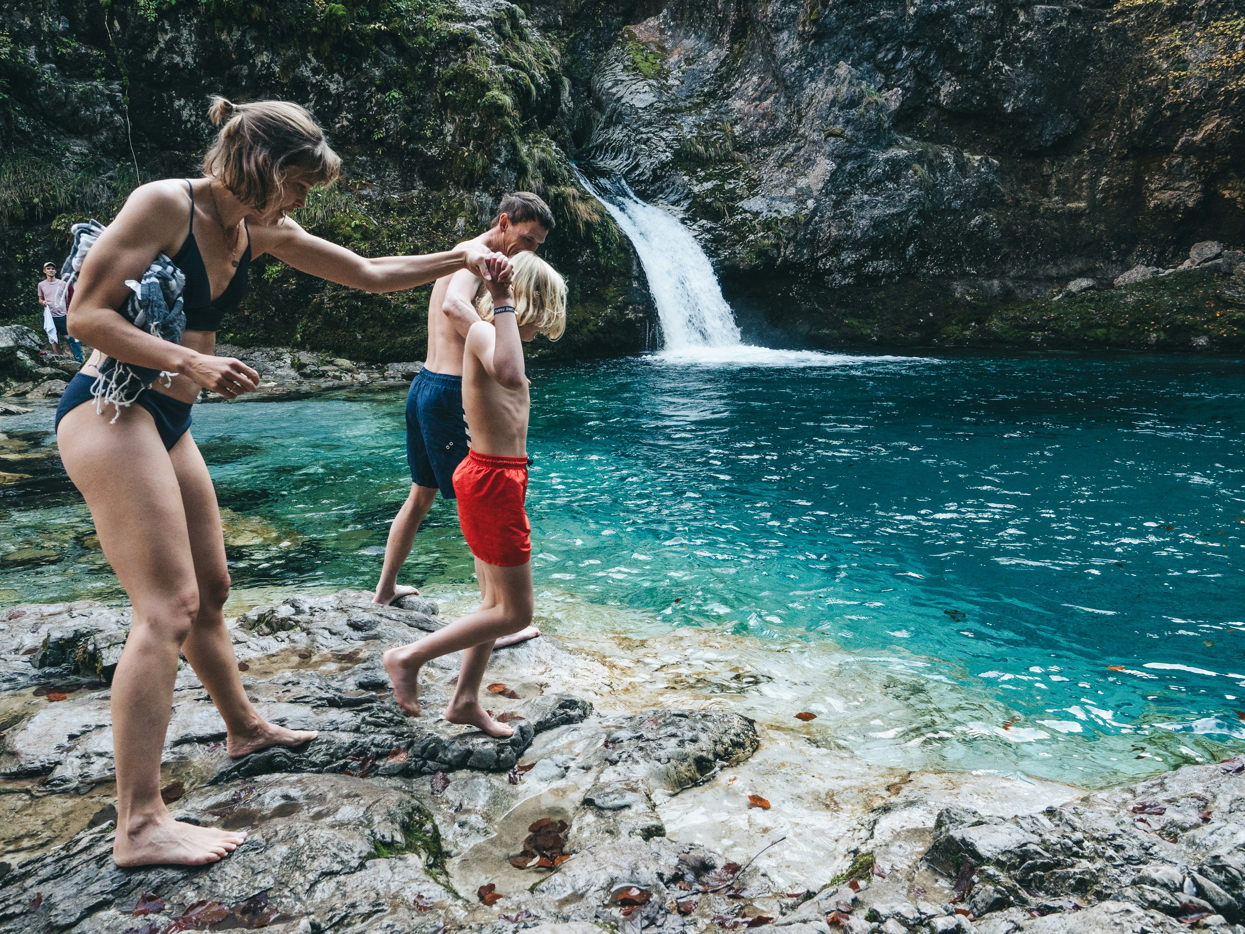 At the end of their hike, a Danish family bathes in the cold water of the "Blue Eye".