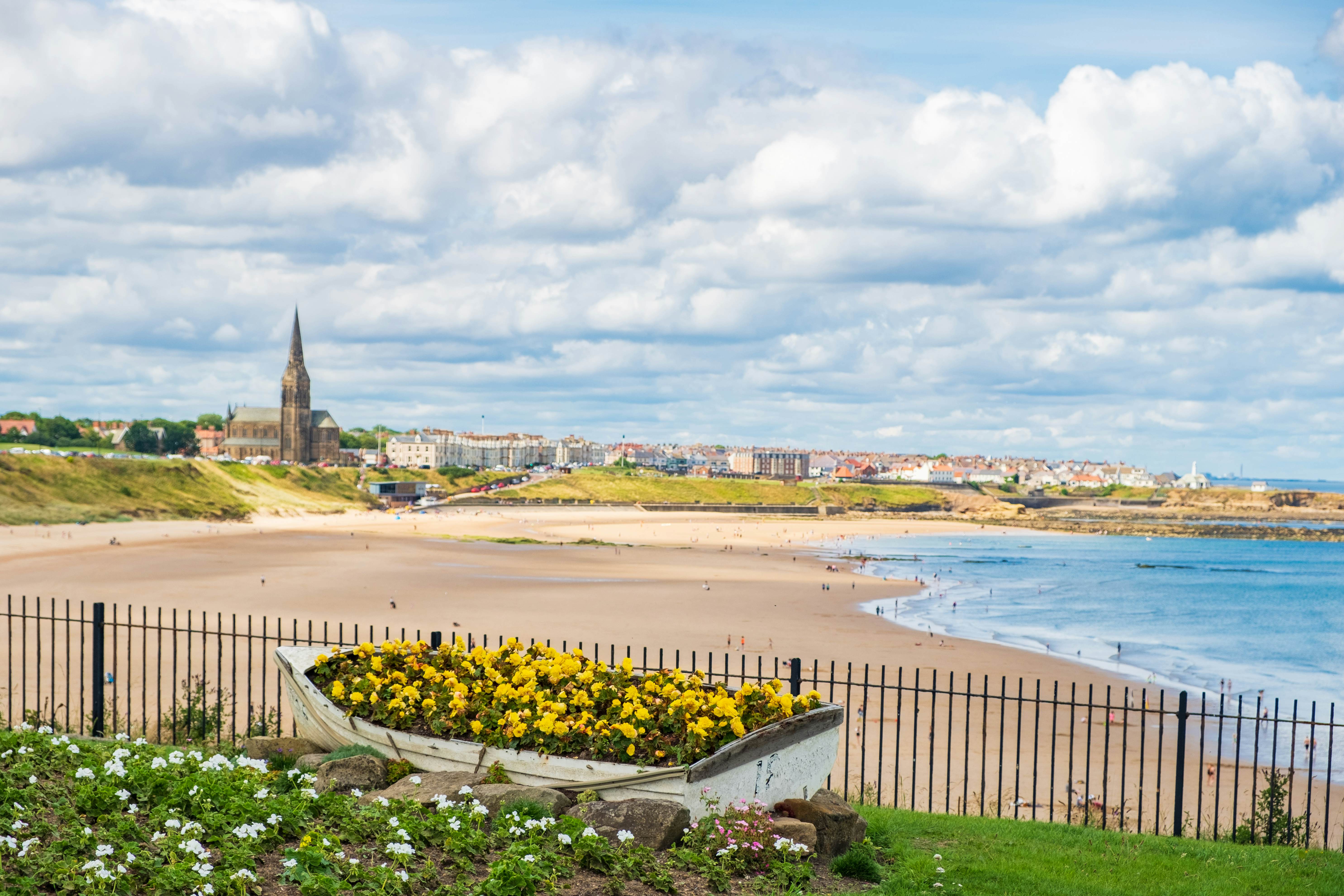 A wide arc of sand forms the beach on the edge of a small town dominated by a church with a tall steeple