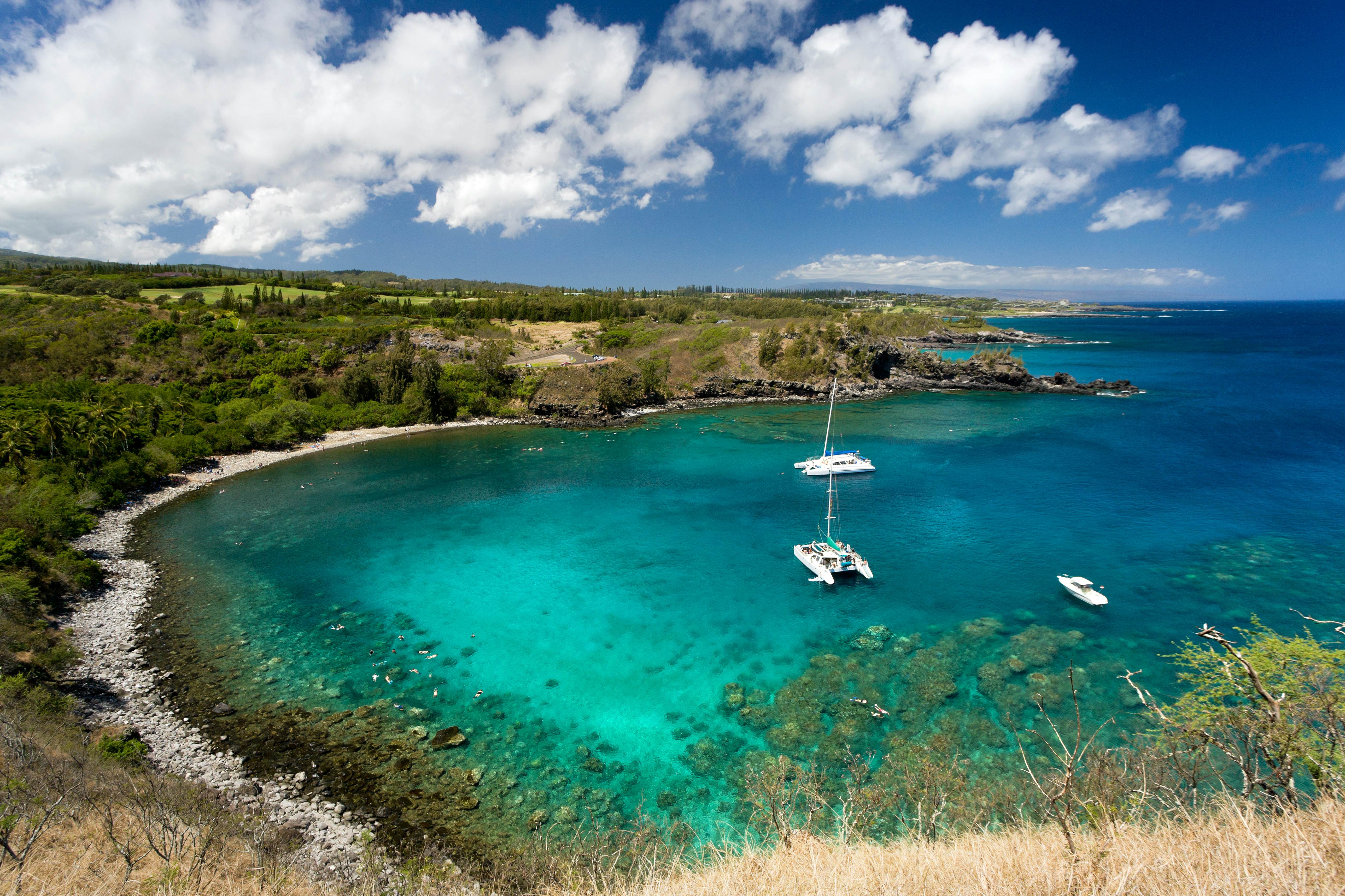 Three ships anchored in a rocky bay