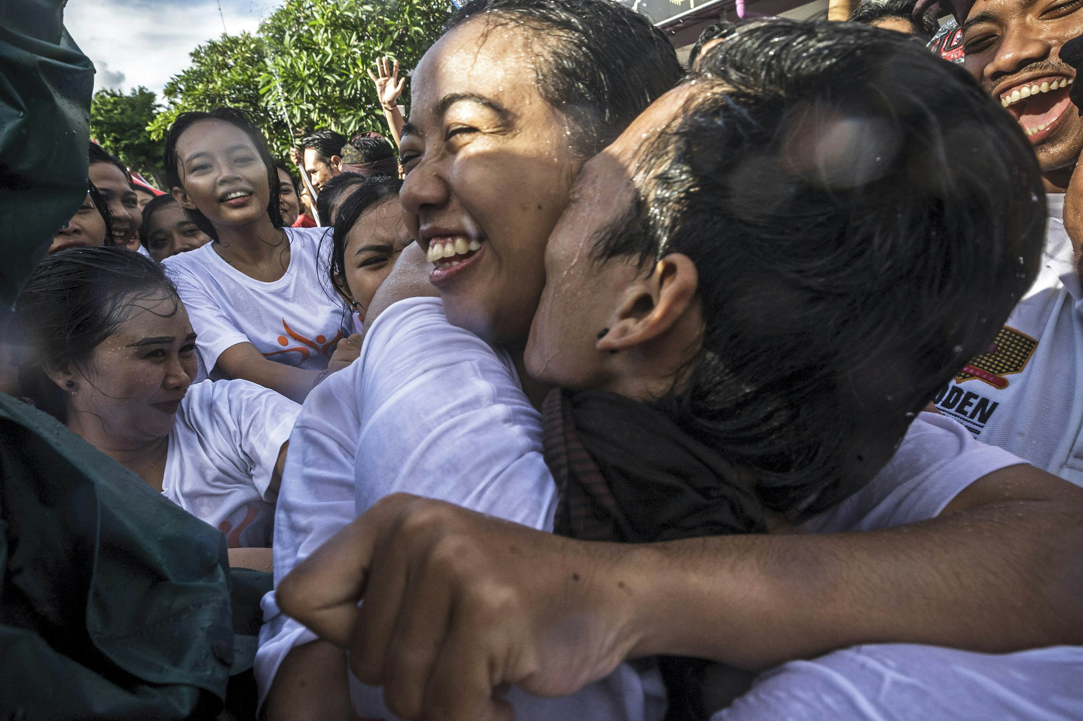 A young Balinese couple kissing each other during the festival known as “omed-omedan” at Sesetan Village, Denpasar, Bali, Indonesia