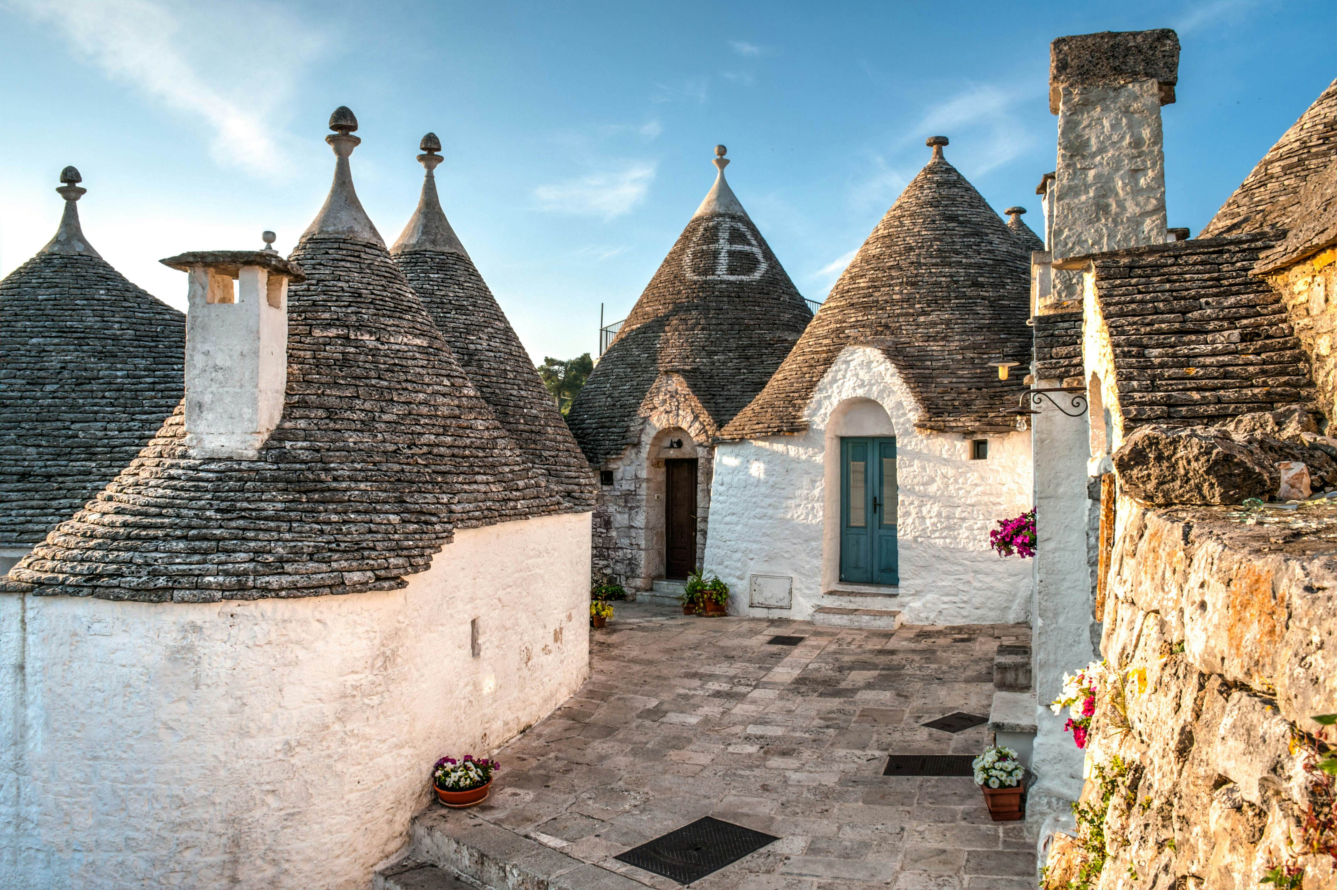 Small round buildings with conical roofs made of stone on a narrow street