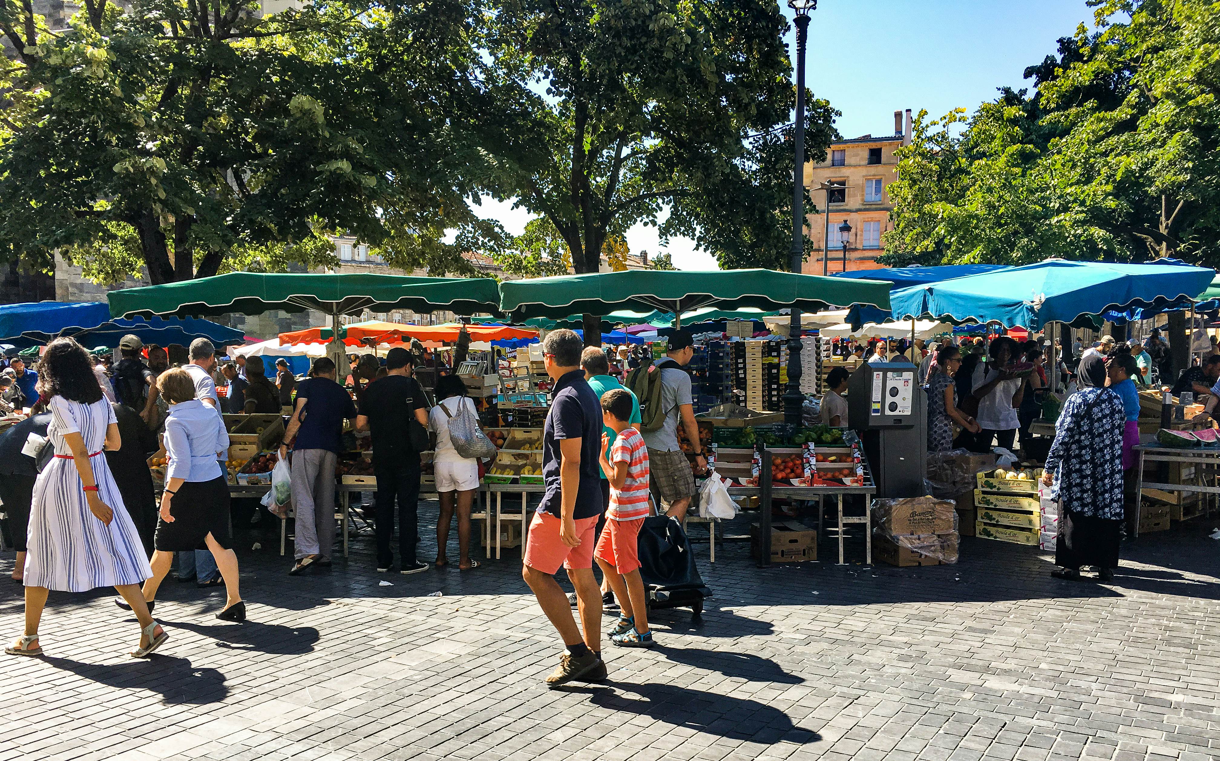 tourists shopping on the Saint-Michel market near the famous Basicila and its spire in Bordeaux