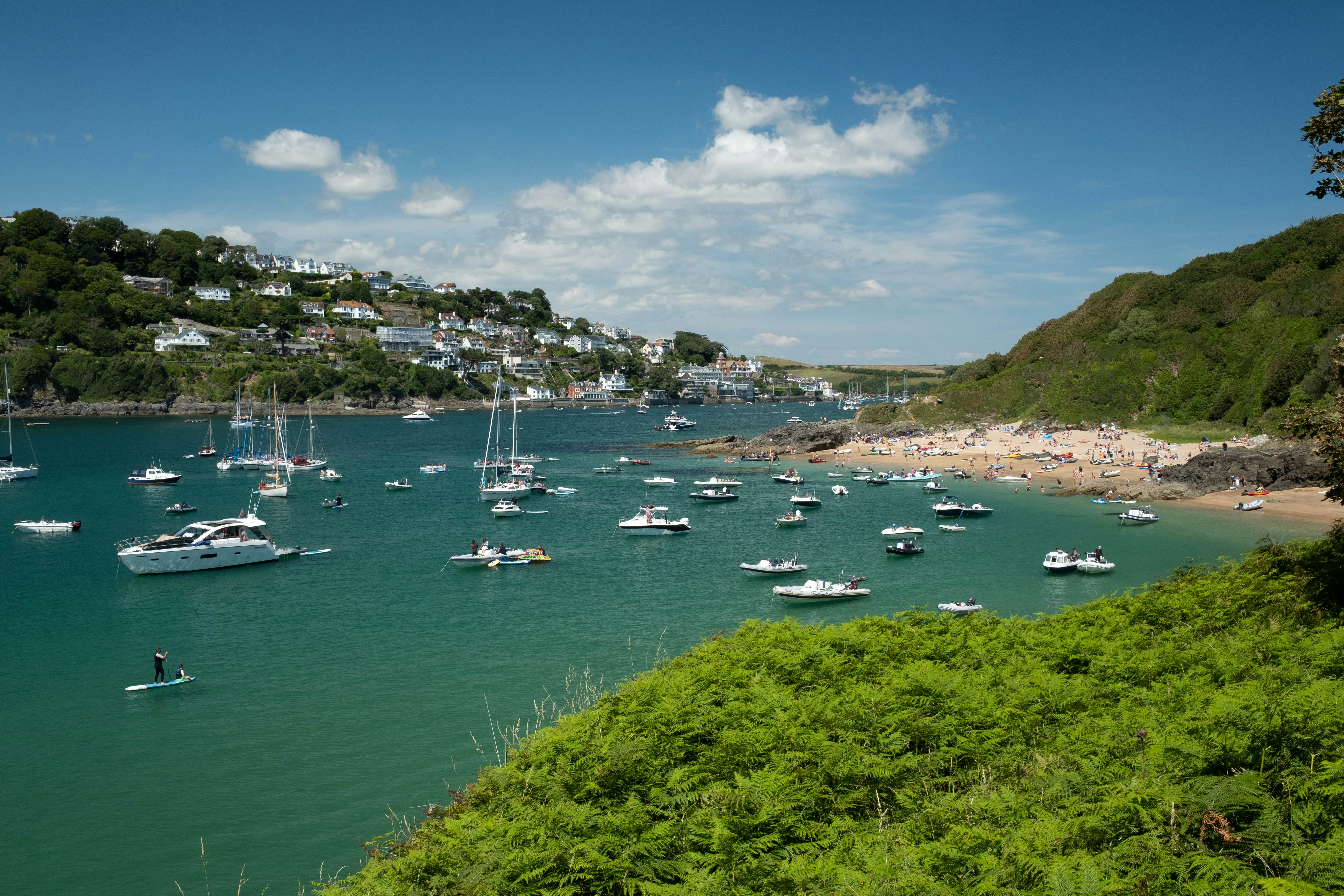 Boats anchored in a sheltered waterway with a small beach