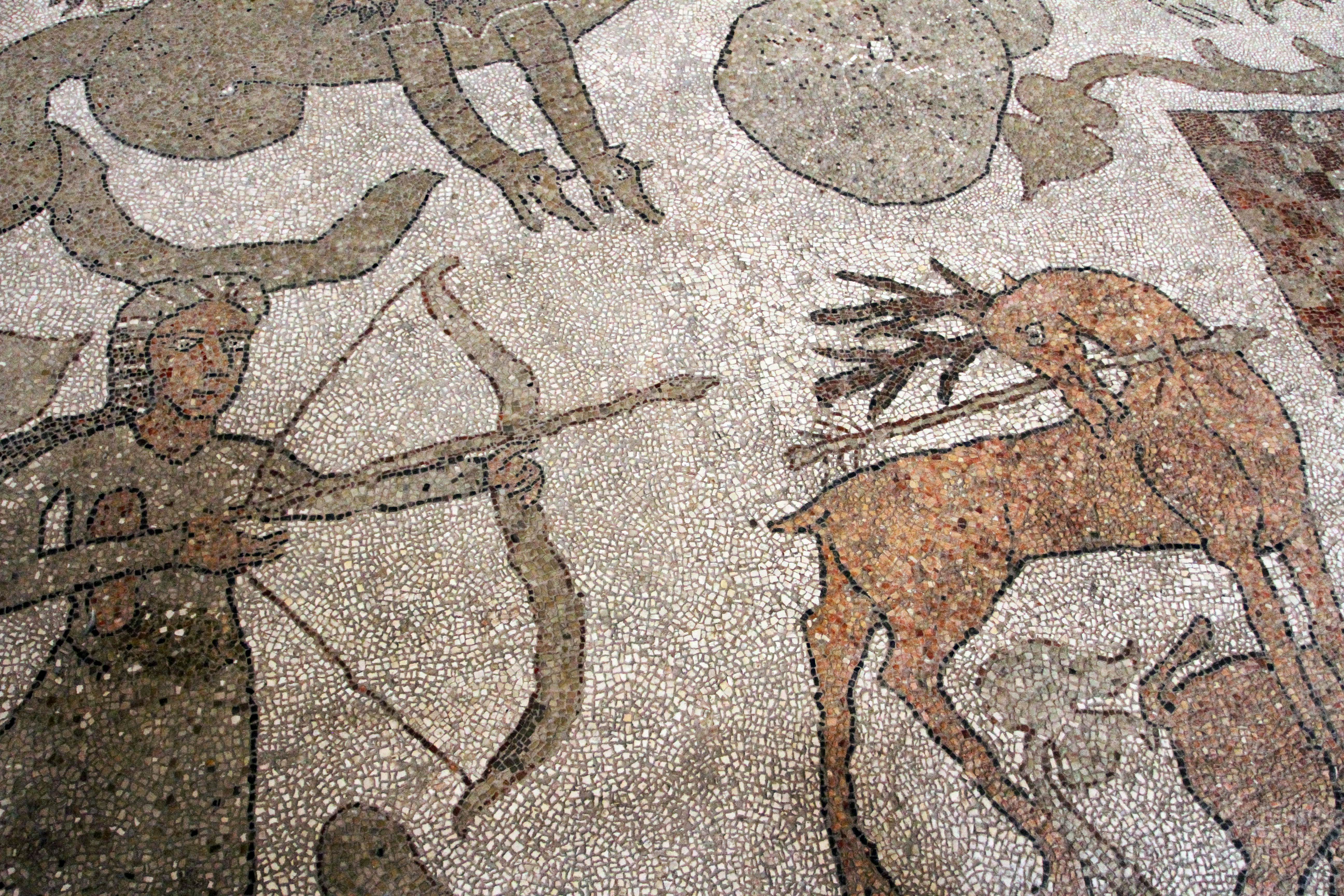 A hunter with a bow and arrow and a stag are depicted in mosaic tiles.