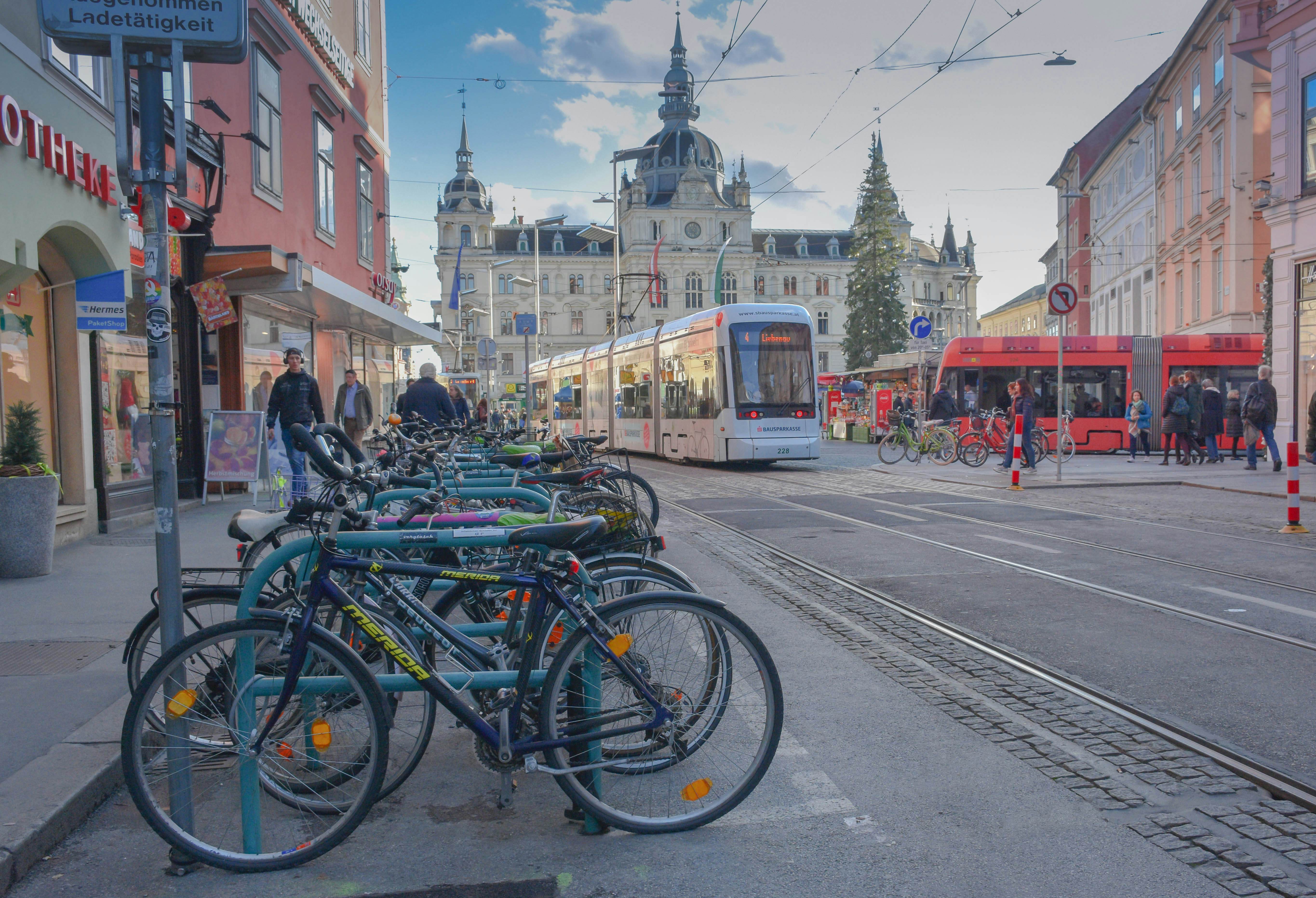 Graz, Austria - November 18, 2019: rush hour with lots of people, trams, cyclist and cars in main square Hauptplatz , Town Hall building in the background, in Graz, Styria region, Austria.