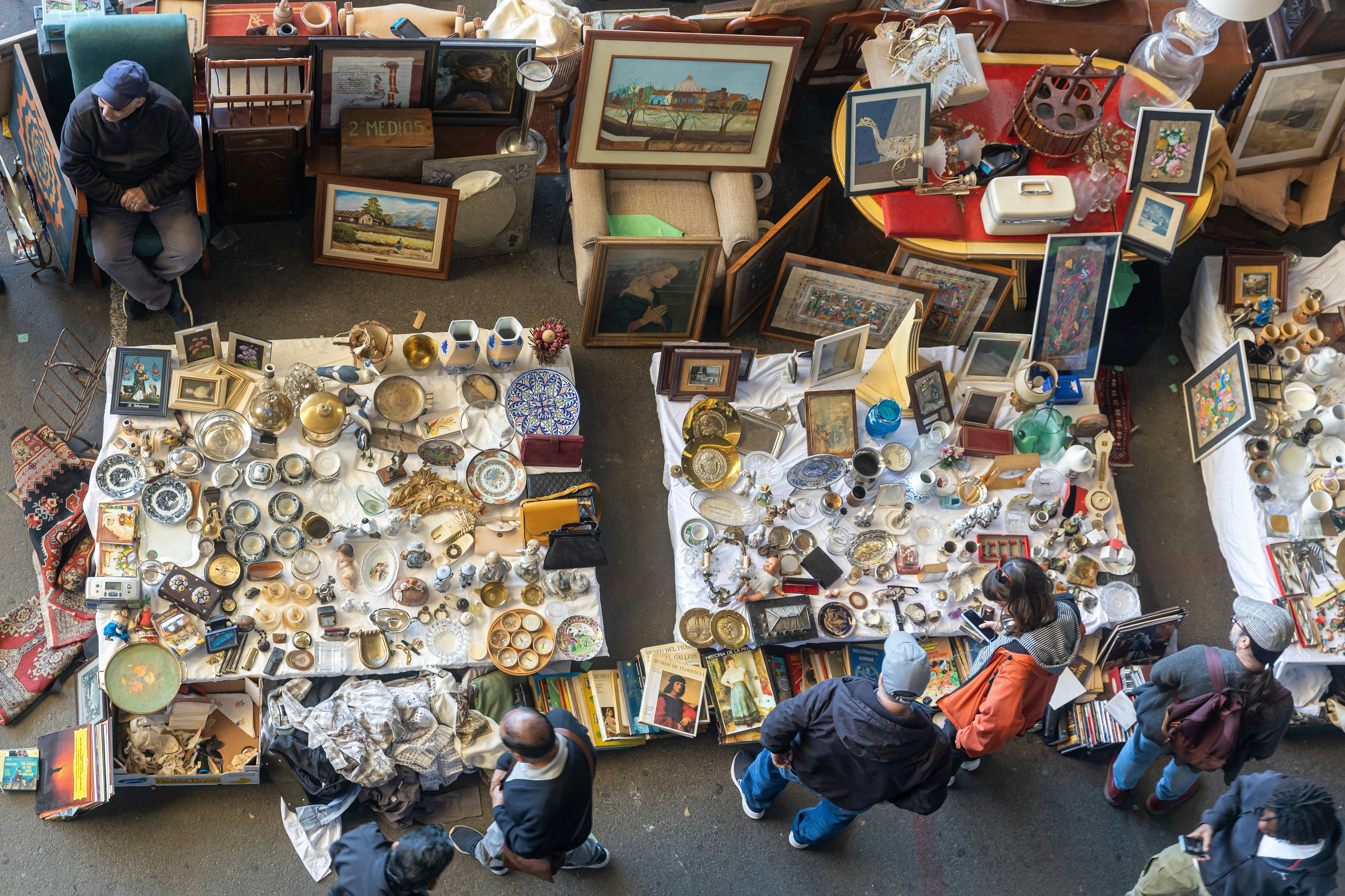 Aerial shot of customers browsing tables of tableware at a flea market