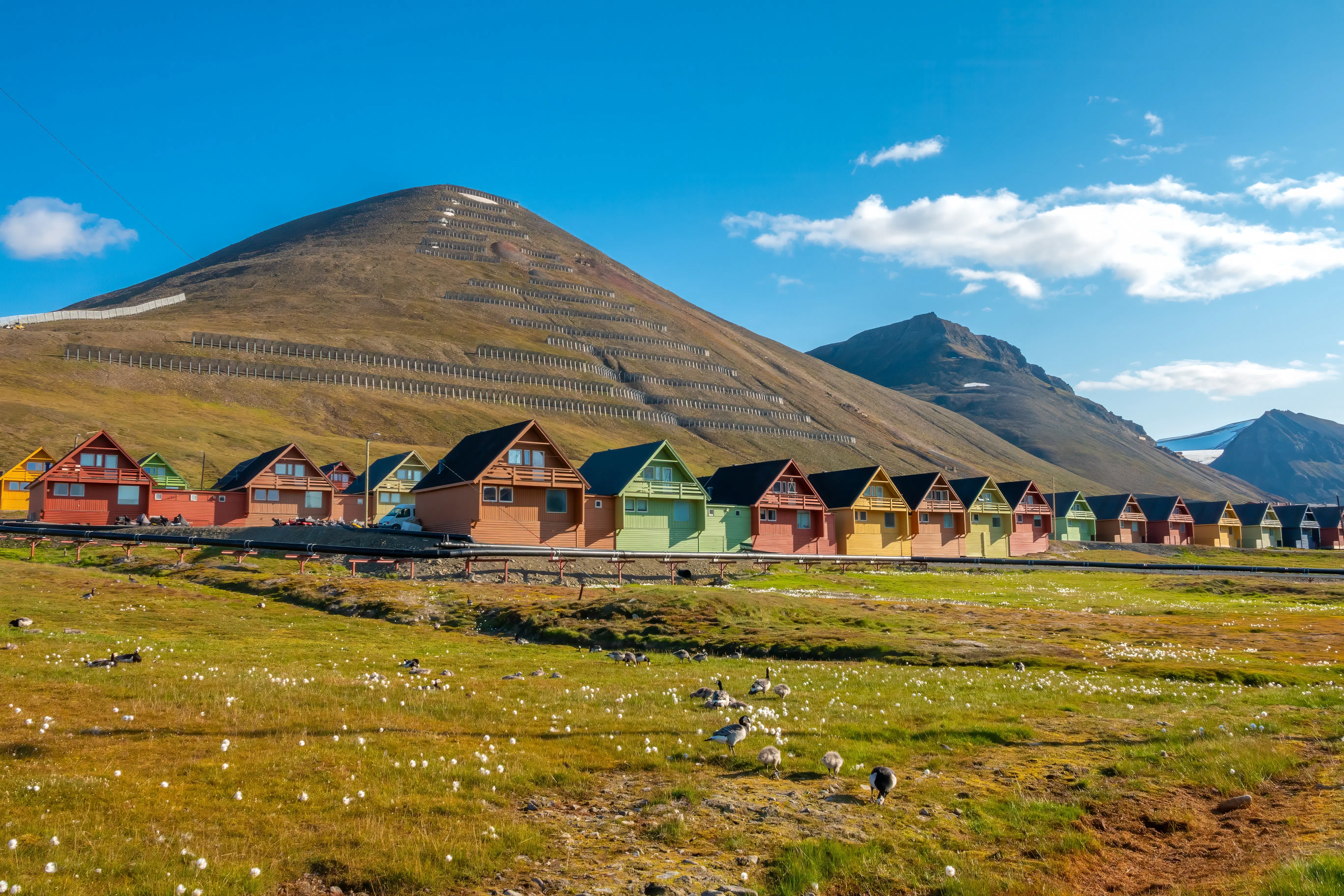 Colorful coal mining houses near the foot of a hill.