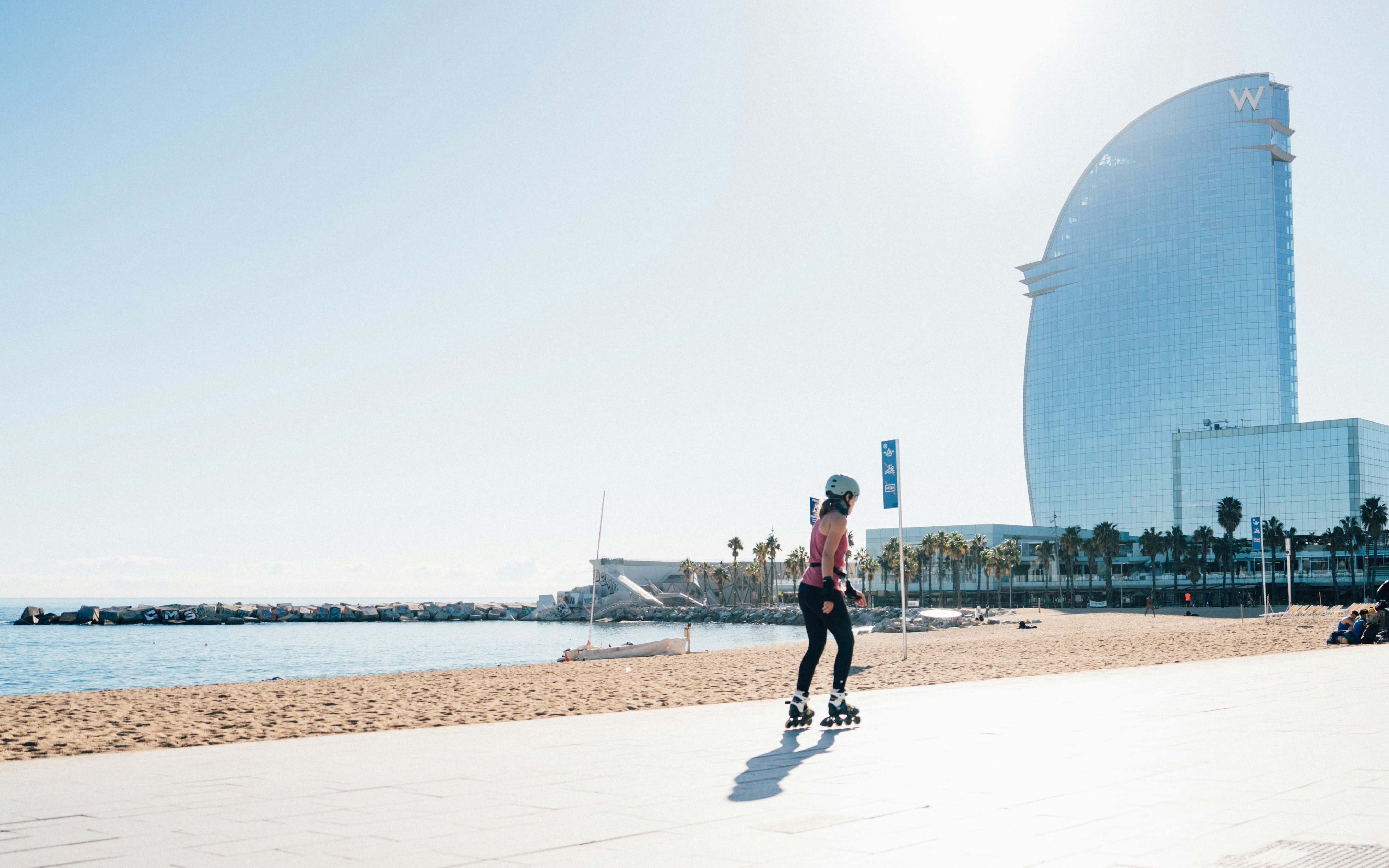 A young girl rollerblading along the Barceloneta beach in Barcelona