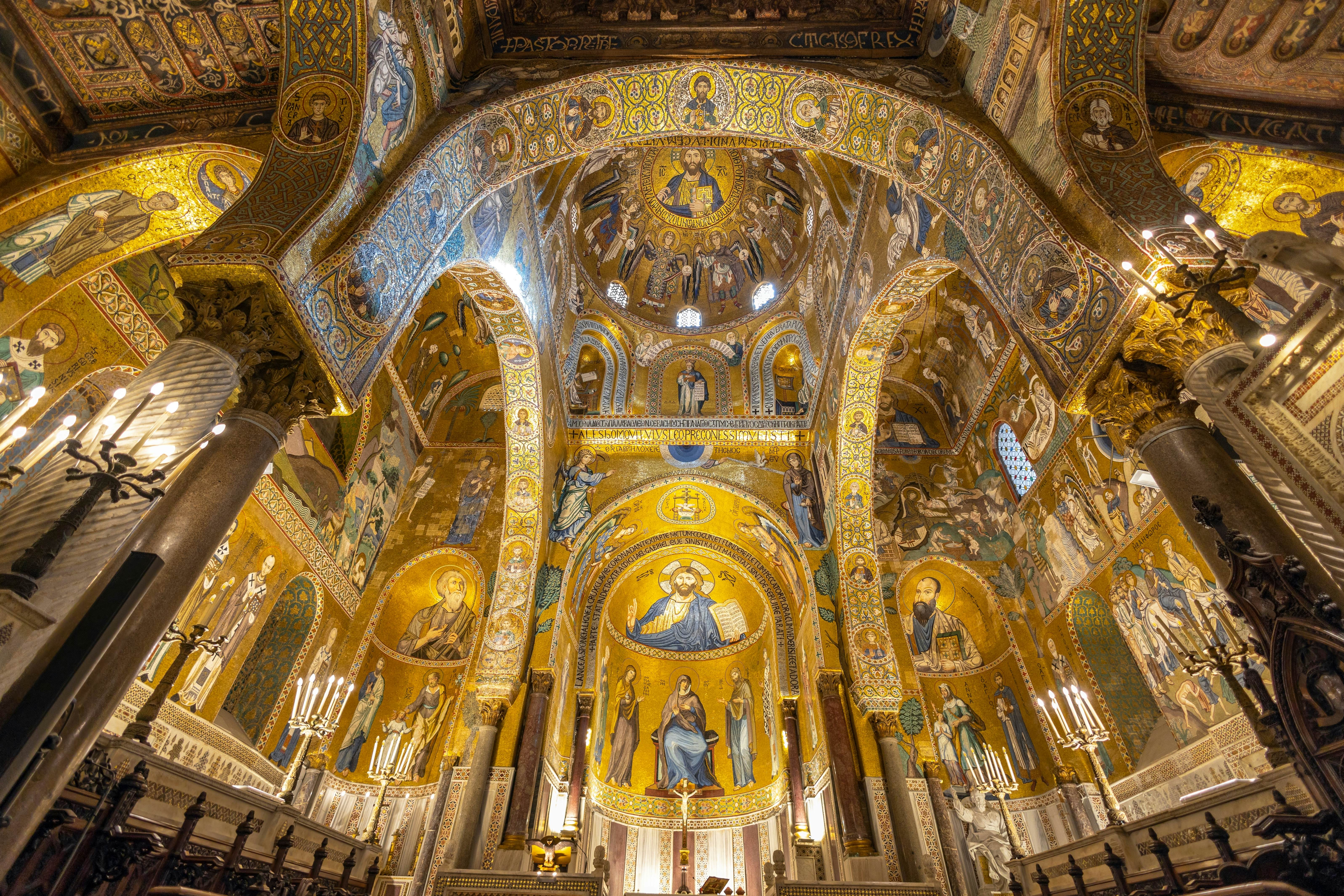 The interior of a church is covered in mosaics, gilt and other ornate details.