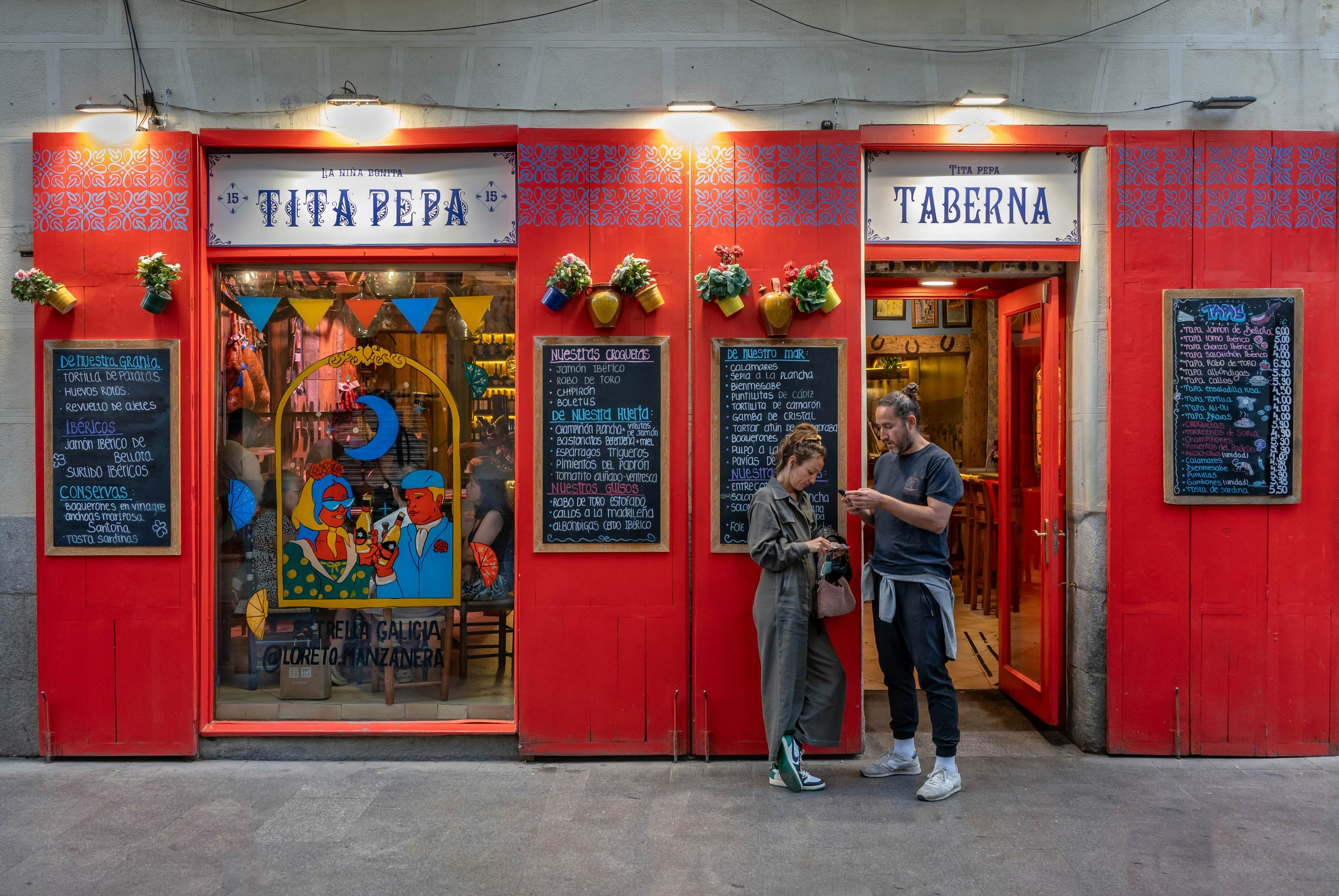 A couple check their phones outside a tapas bar in Madrid.