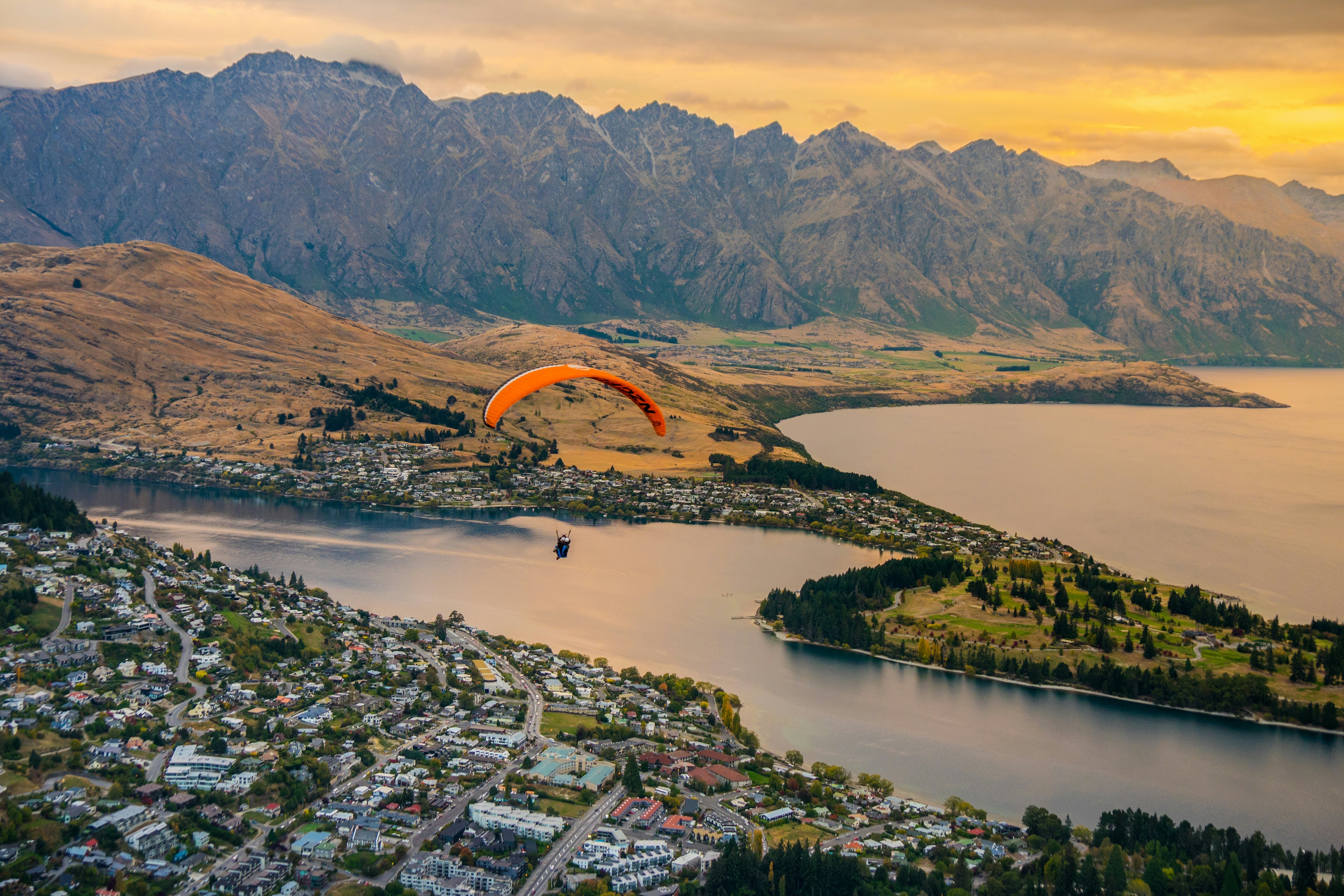 Paragliding over Queenstown and Lake Wakaitipu with The Remarkables in the background, looking from the viewpoint at Queenstown Skyline, New Zealand