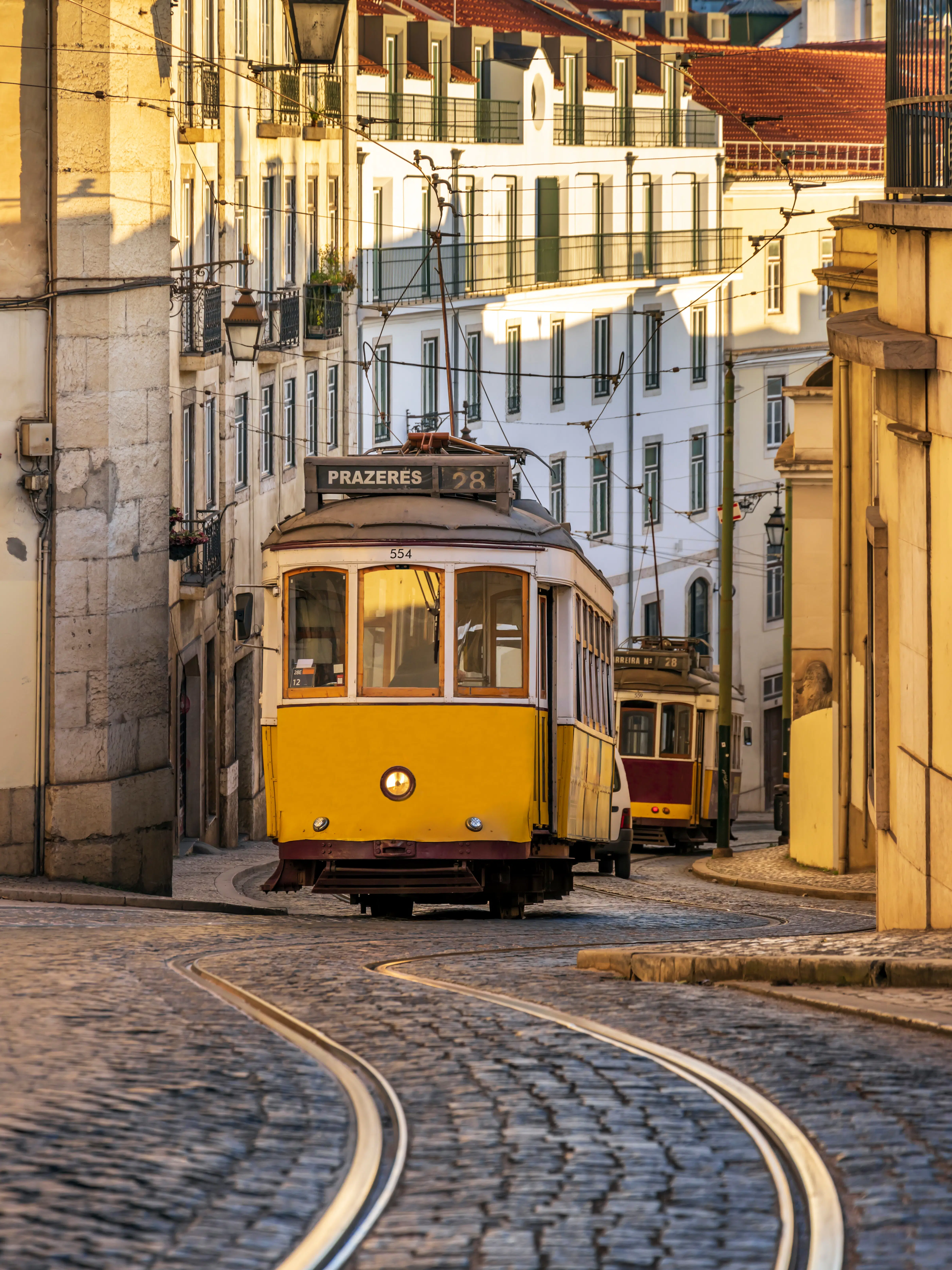 A yellow tram car follows grooves up a hill