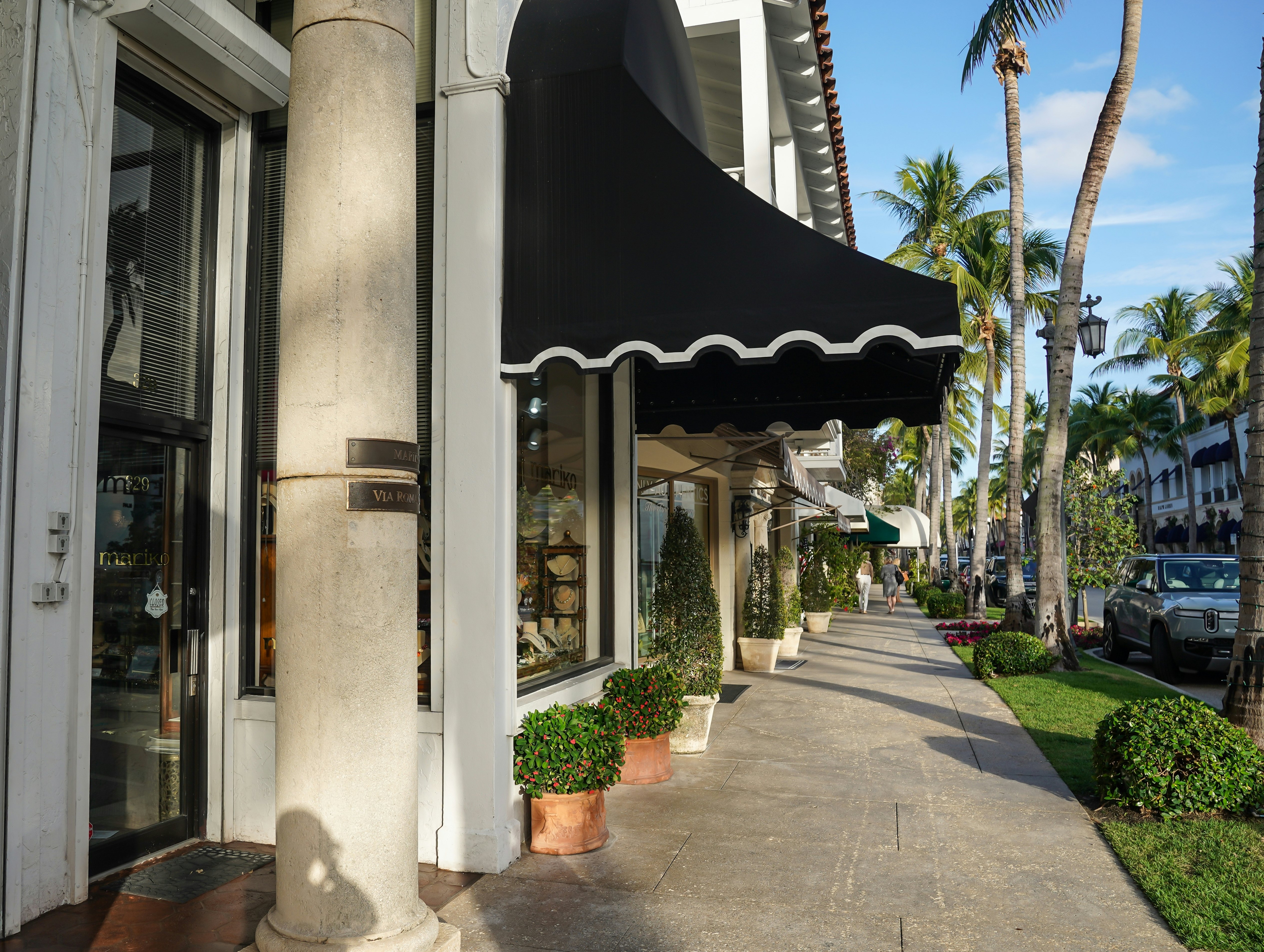 Awnings extend over the sidewalk of an upscale shopping and dining district in Florida.