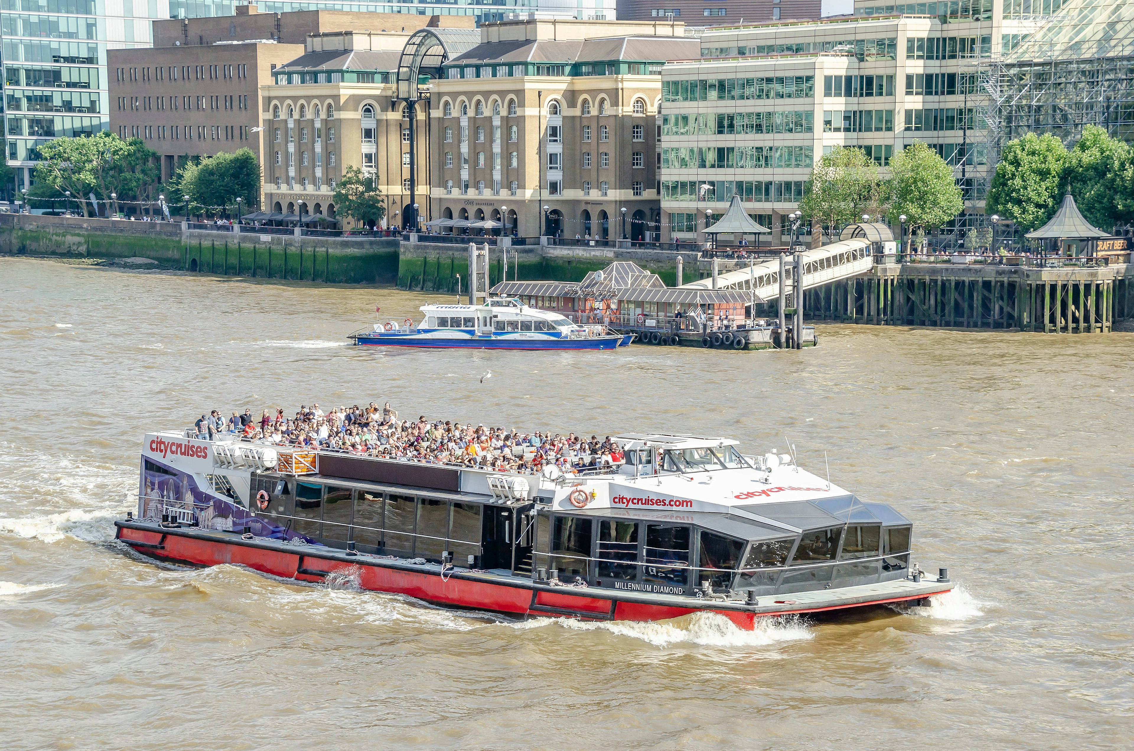 Tourist boats, laden with passengers, sailing along a river