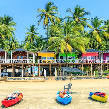 Colourful bungalows and kayaks on Palolem beach, Goa, India.