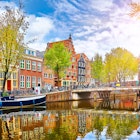 Channel in Amsterdam Netherlands houses river Amstel landmark old european city spring landscape.