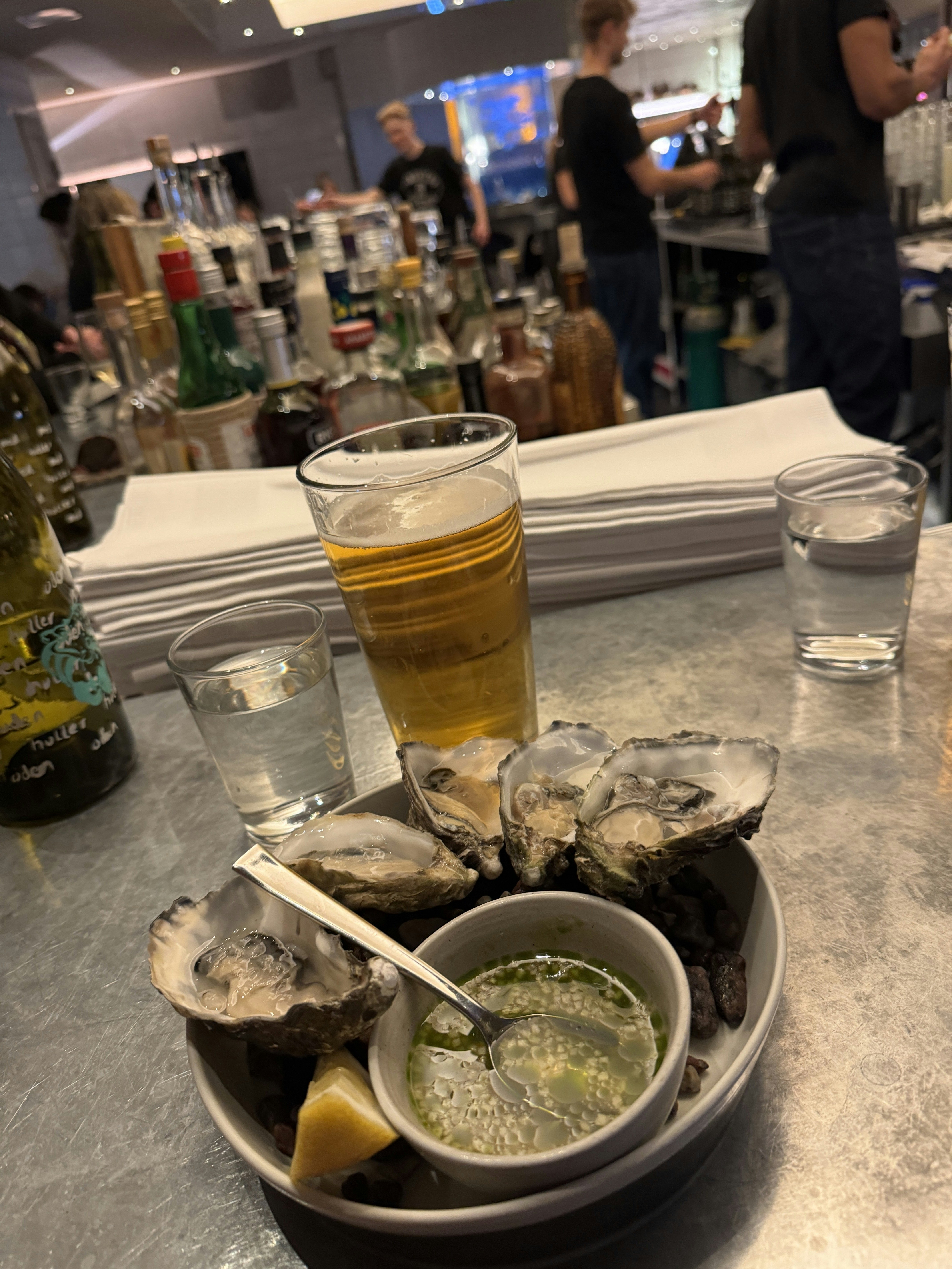 Close-up of oysters in a bowl on a metal table.