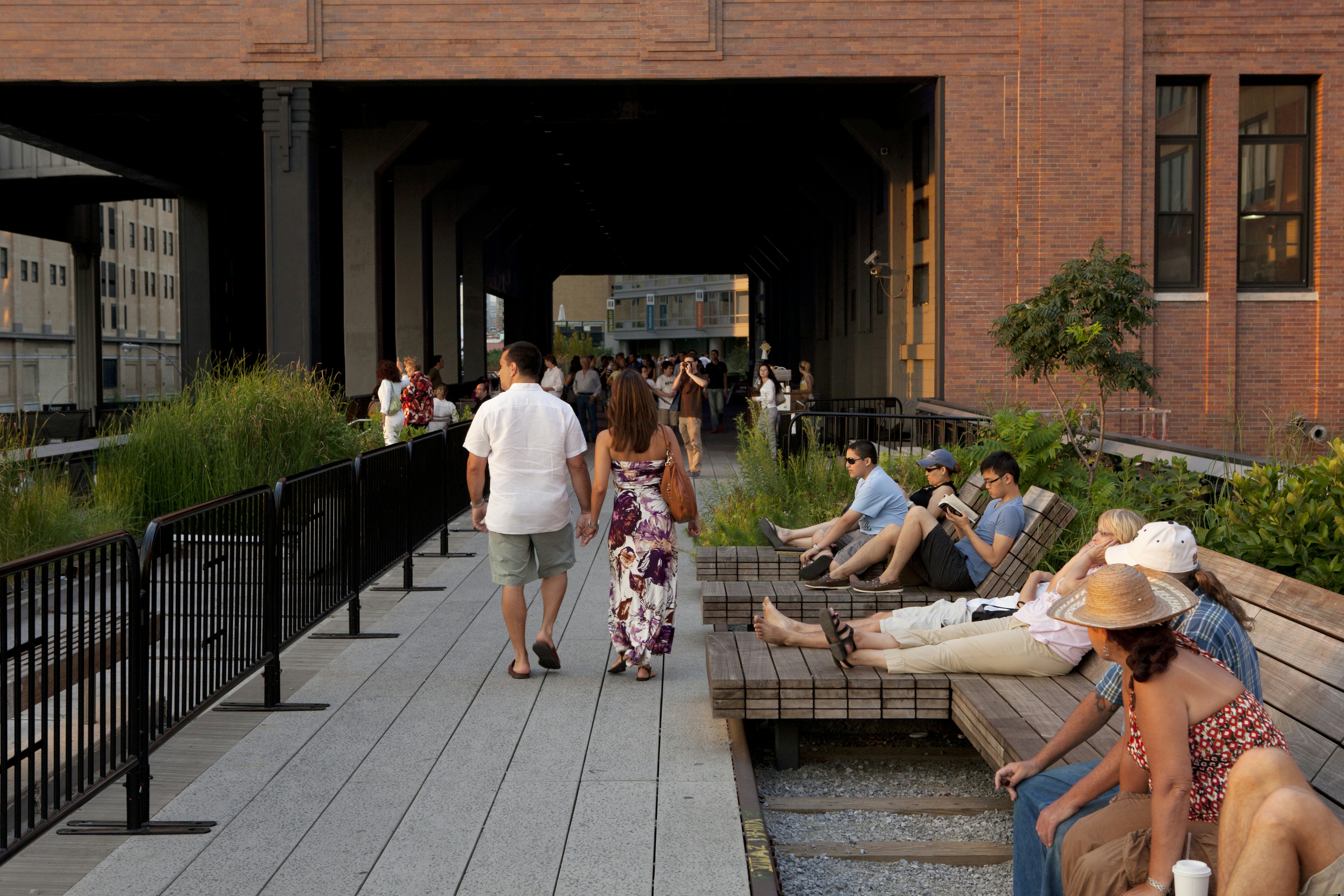 People strolling and seated as they enjoy the High Line on a sunny day