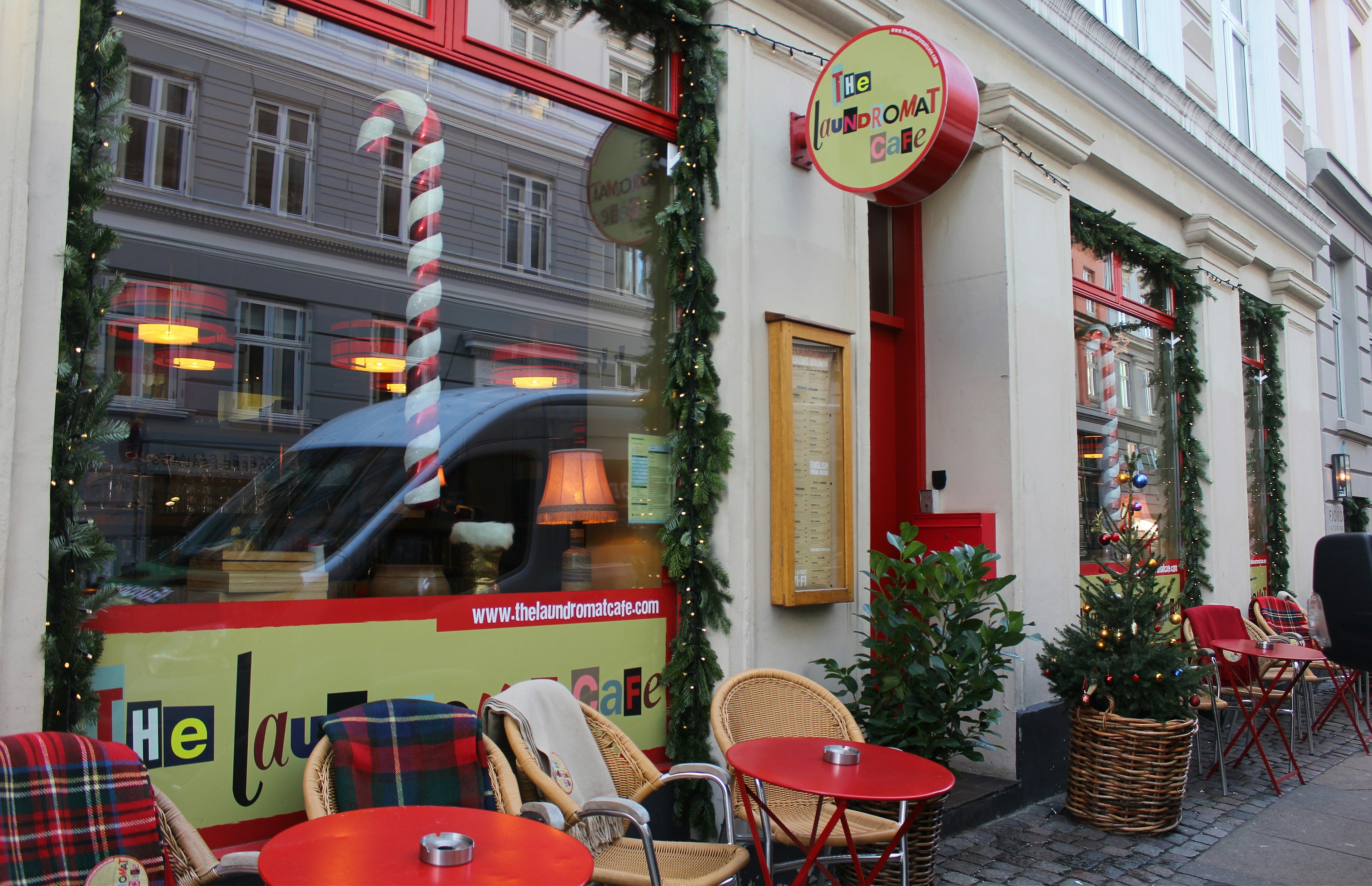 Chairs, tables and potted plants outside The Laundromat Cafe in Copenhagen