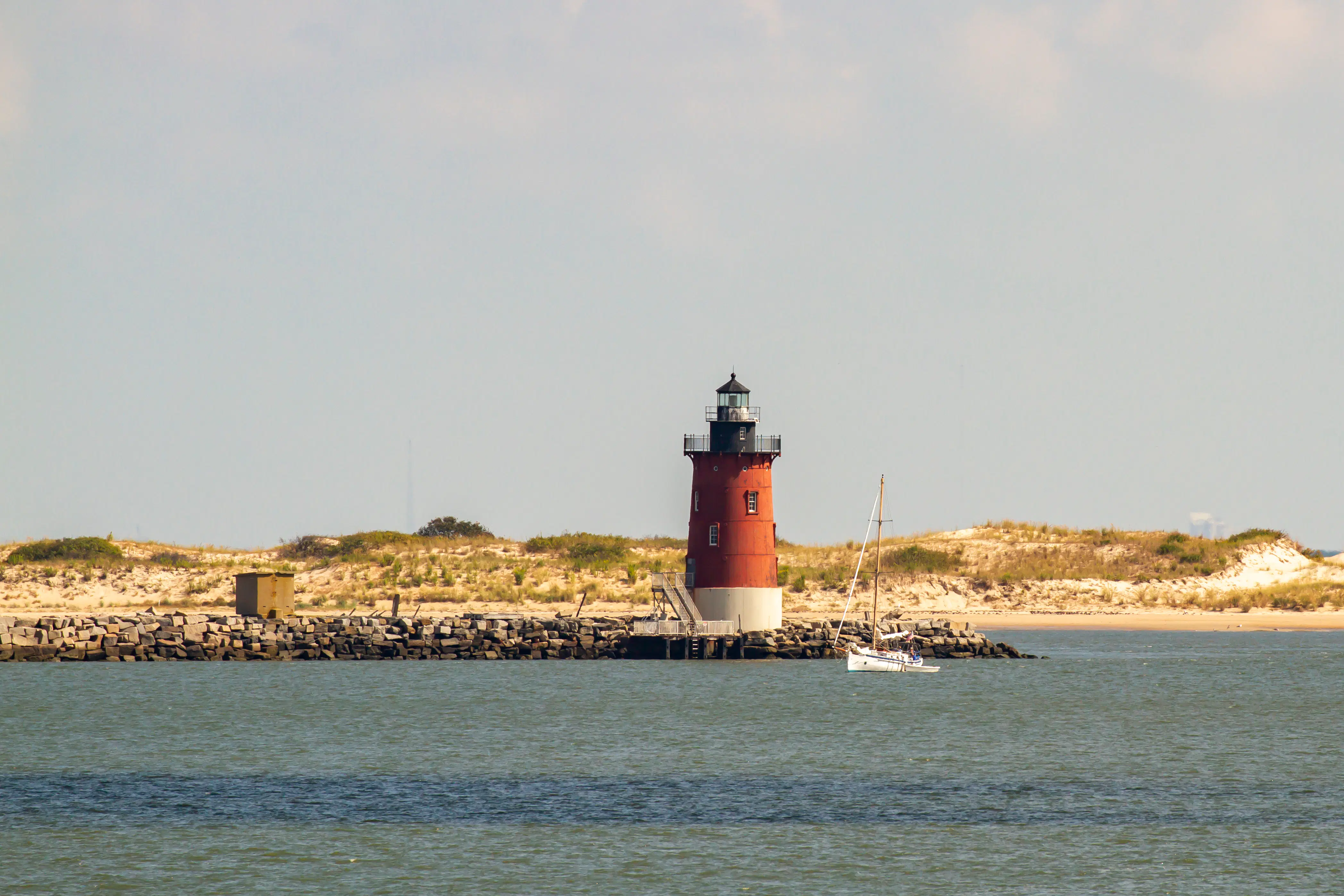 Delaware Breakwater East End Lighthouse and sailboat off the coast of Lewes, Delaware