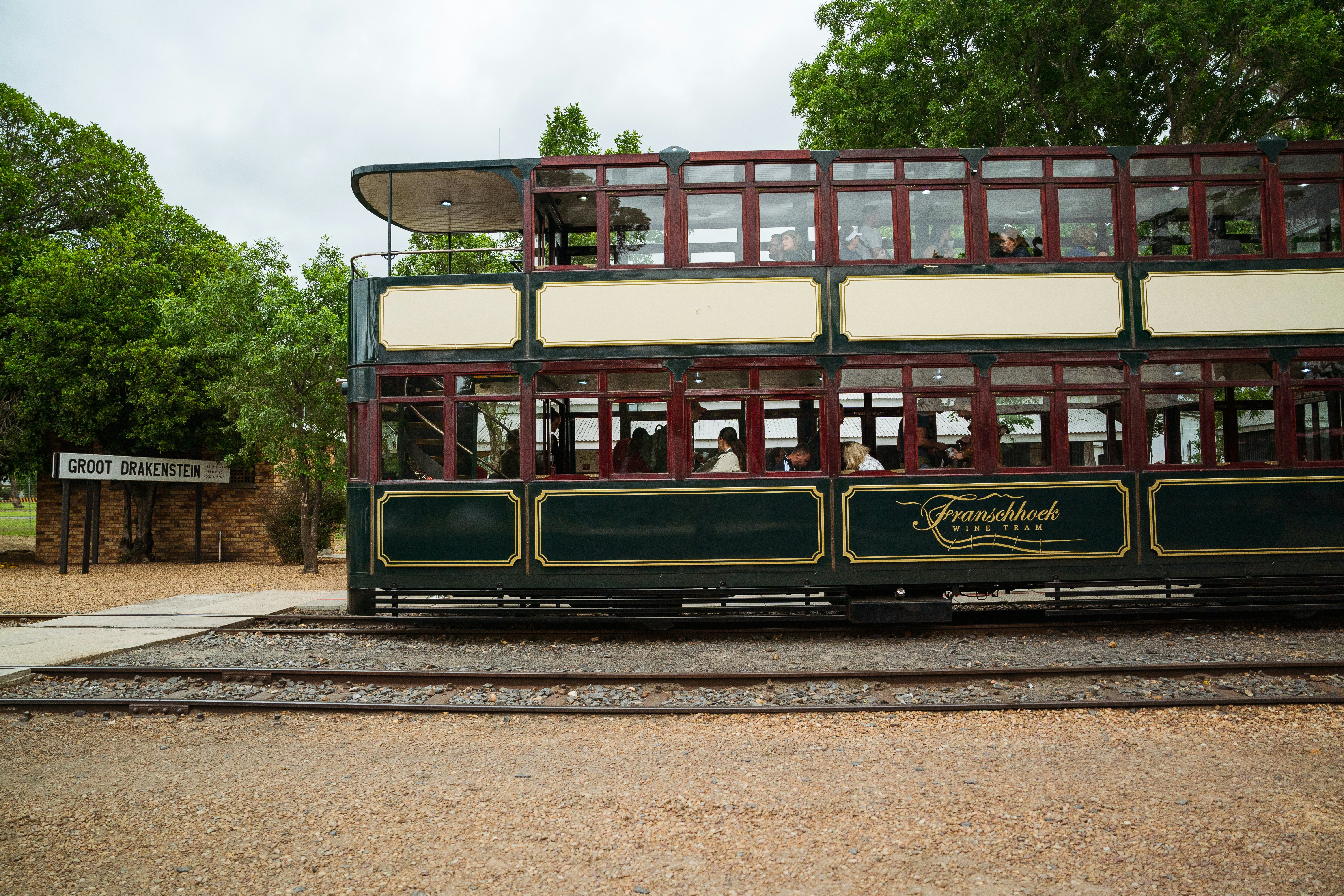 A green double decker tram with red trimmed windows