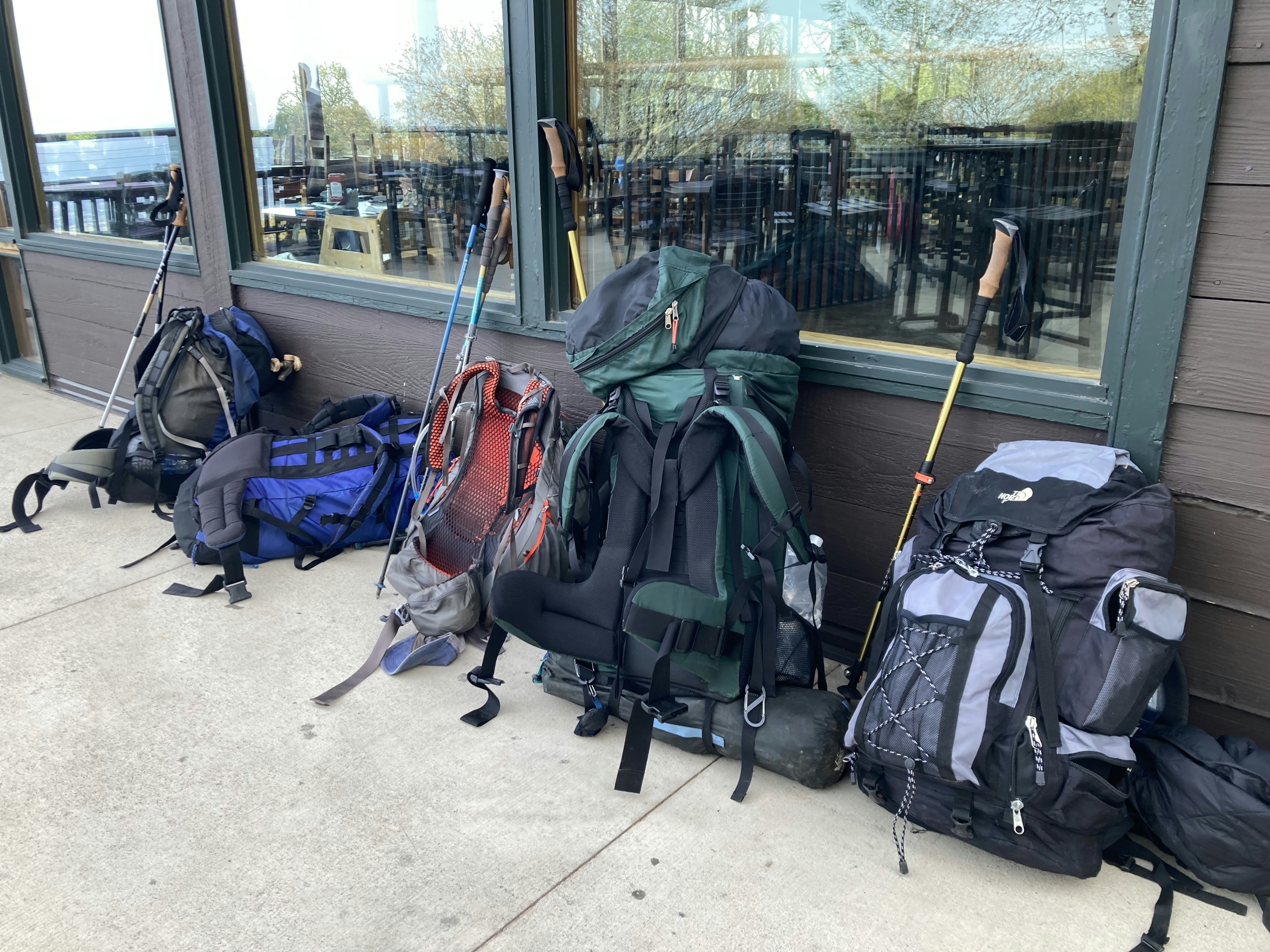 Backpacks lean up against the side of a lodge