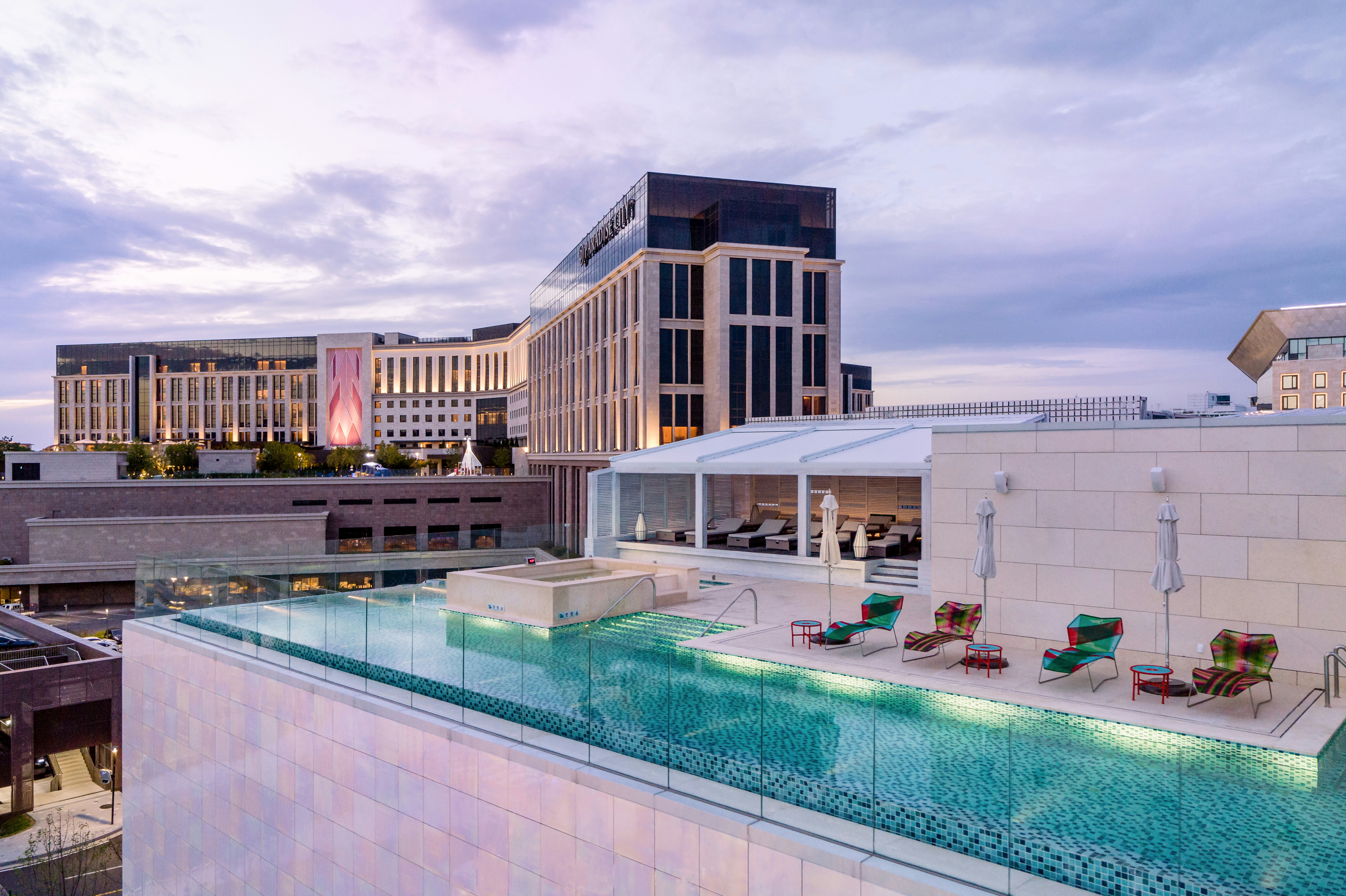 A rooftop infinity pool with sunloungers on a small terrace.