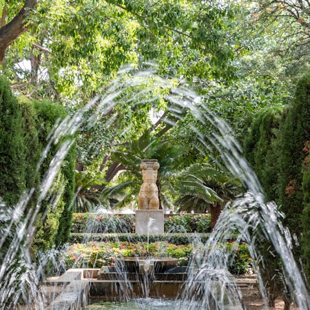 Fountain water arches in the lush gardens