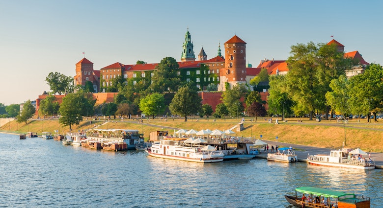 Krakow, Poland - August 11, 2017: panoramic view of the famous Wawel Castle, located on a hill, boats in the Wisla River; Shutterstock ID 1080226838; your: Brian Healy; gl: 65050; netsuite: Lonely Planet Online Editorial; full: Getting around Krakow