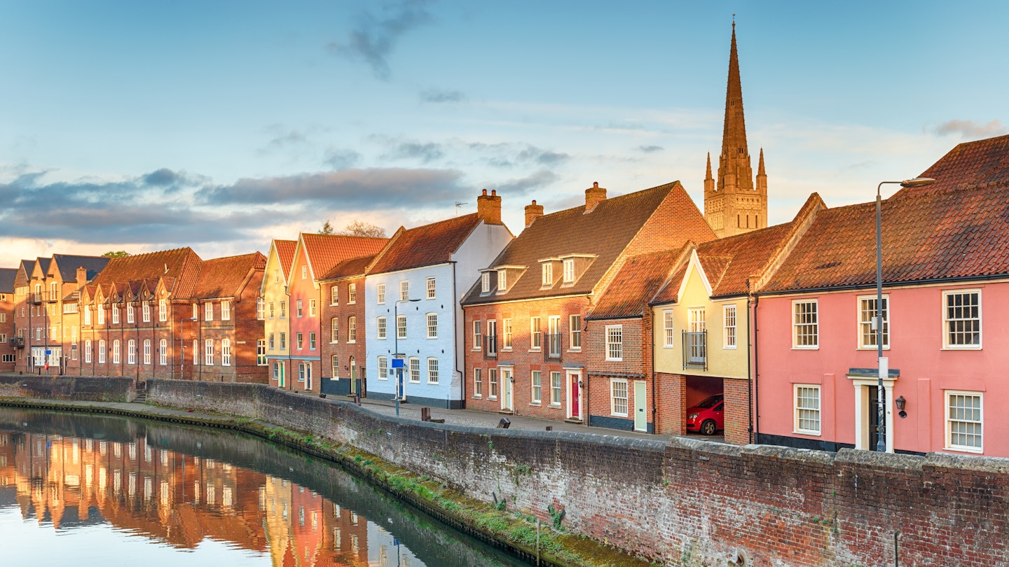 A view along the Wensum River in Norwich, Norfolk, UK, with the spire of Norwich Cathedral.