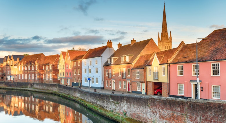 A view along the Wensum River in Norwich, Norfolk, UK, with the spire of Norwich Cathedral.