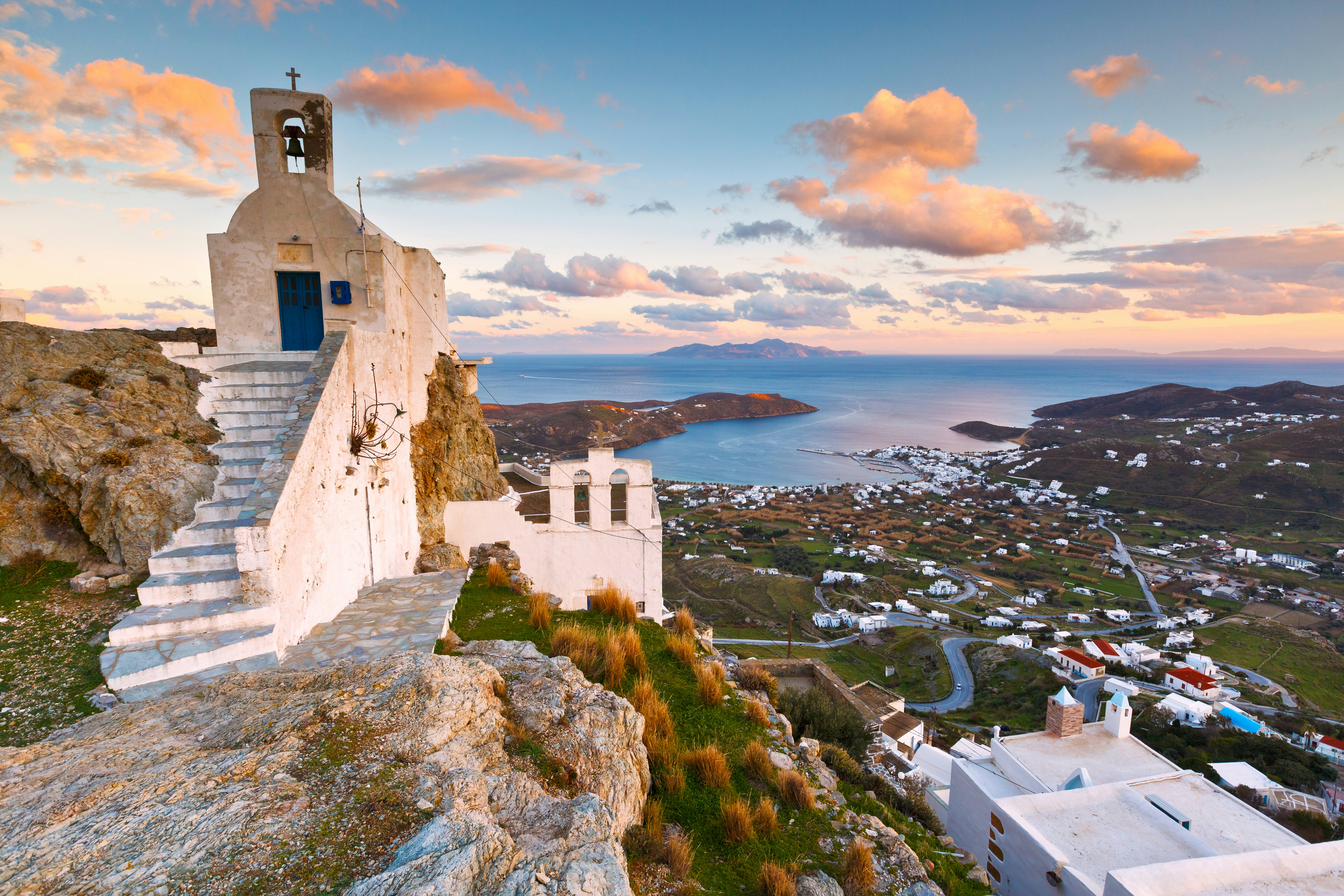 A view of a typical Greek church and harbour with big sky.