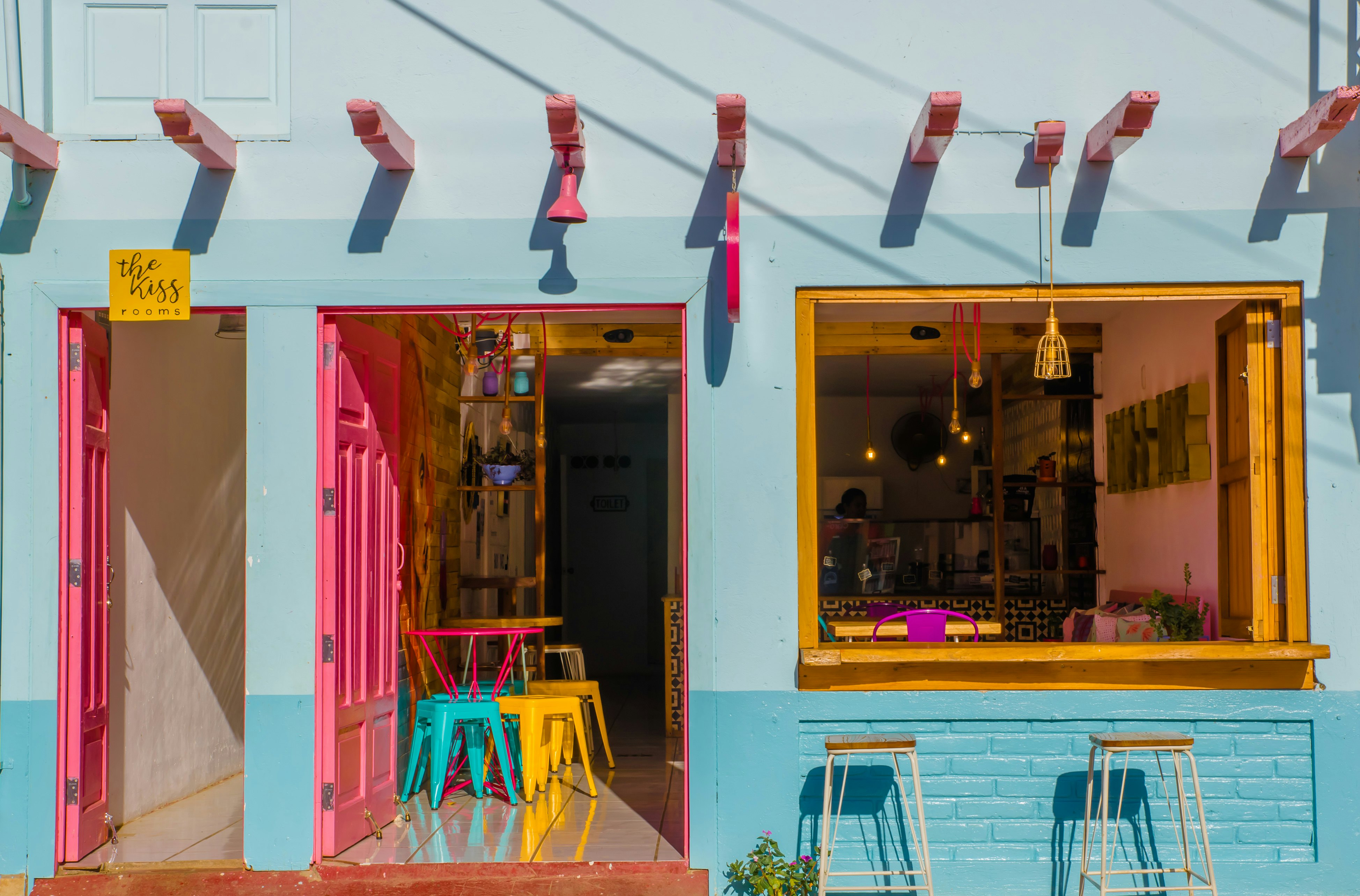 Close-up of turquoise, pink and yellow artisan ice cream restaurant on a sunny day.