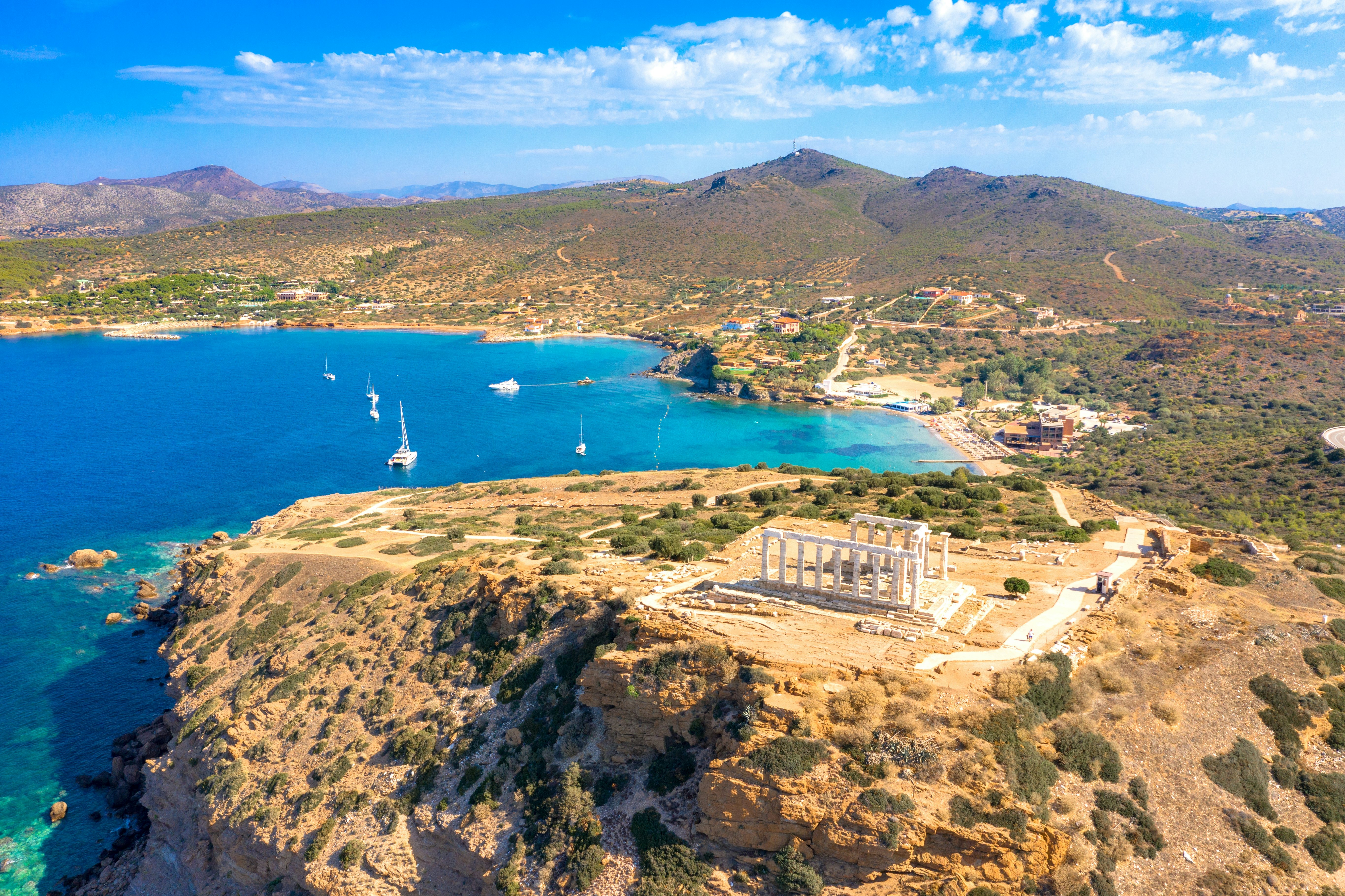 The cliffside ruins of a marble temple overlooking clear blue sea