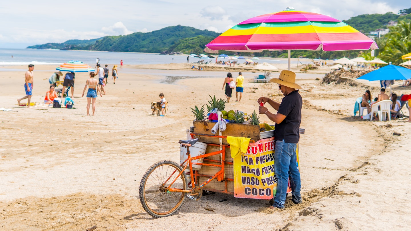 Sayulita, Mexico - September 16, 2021 - candid photography of a street vendor and people on Sayulita Beach, License Type: media, Download Time: 2025-06-04T19:40:46.000Z, User: Sarahstocking, Editorial: true, purchase_order: 65050 - Digital Destinations and Articles, job: Digital, client: First time guide Riviera Nayarit, other: Sarah Stocking