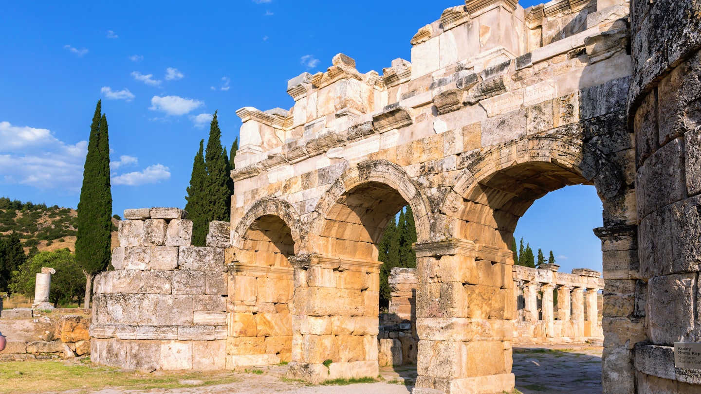 Hierapolis Frontinus Gate against blue sky and green landscape. Close up view of entrance to ancient Greek and Roman city. Pamukkale, Denizli, Turkey (Turkiye), License Type: media, Download Time: 2024-08-02T08:08:41.000Z, User: catalinaaragon, Editorial: false, purchase_order: 56530, job: Global Publishing-WIP, client: Turkey 17, other: CatalinaAragón