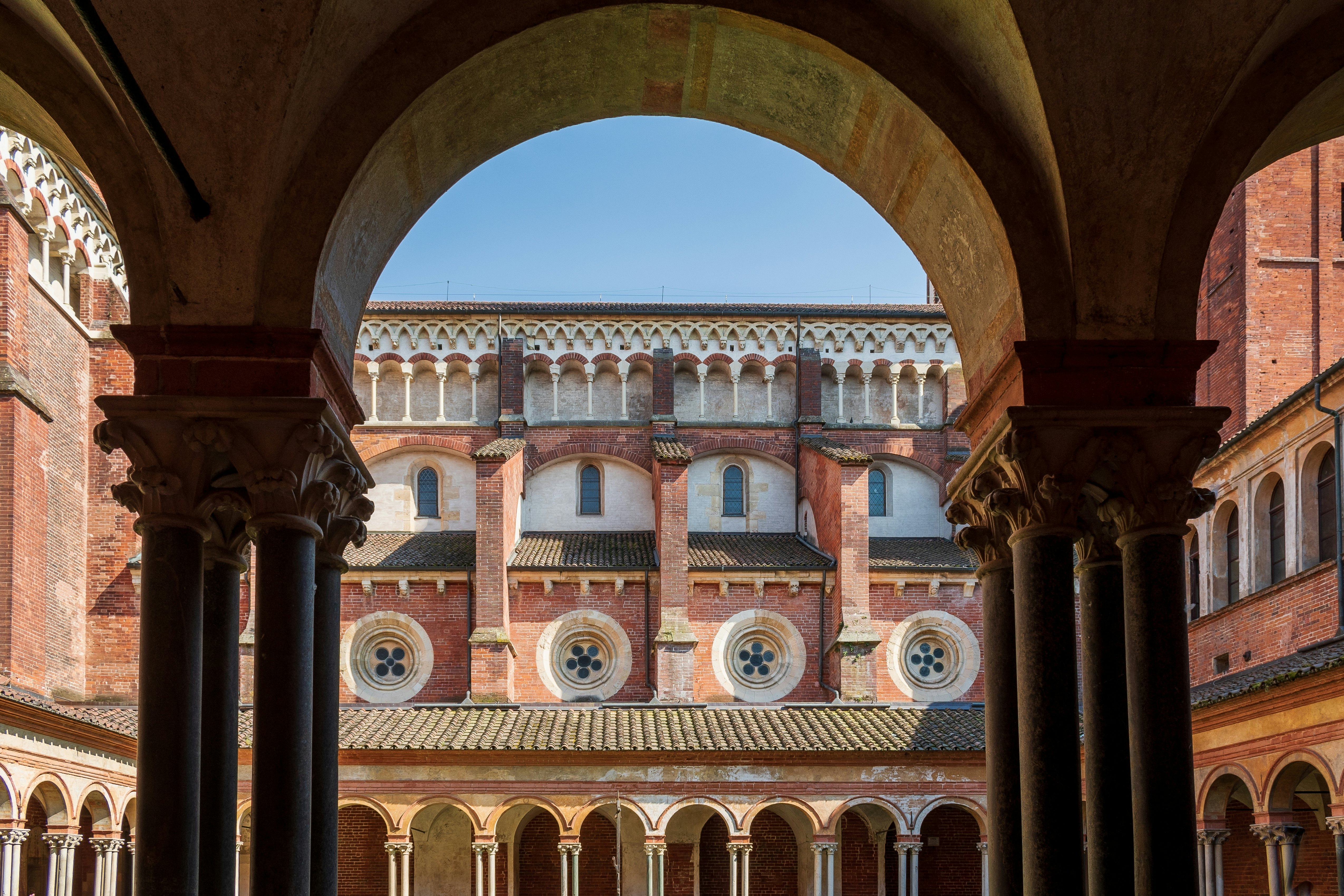 A view from a covered passageway of the side of a Gothic church.