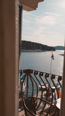 View of a sparkling sea and sailboats off a hotel balcony