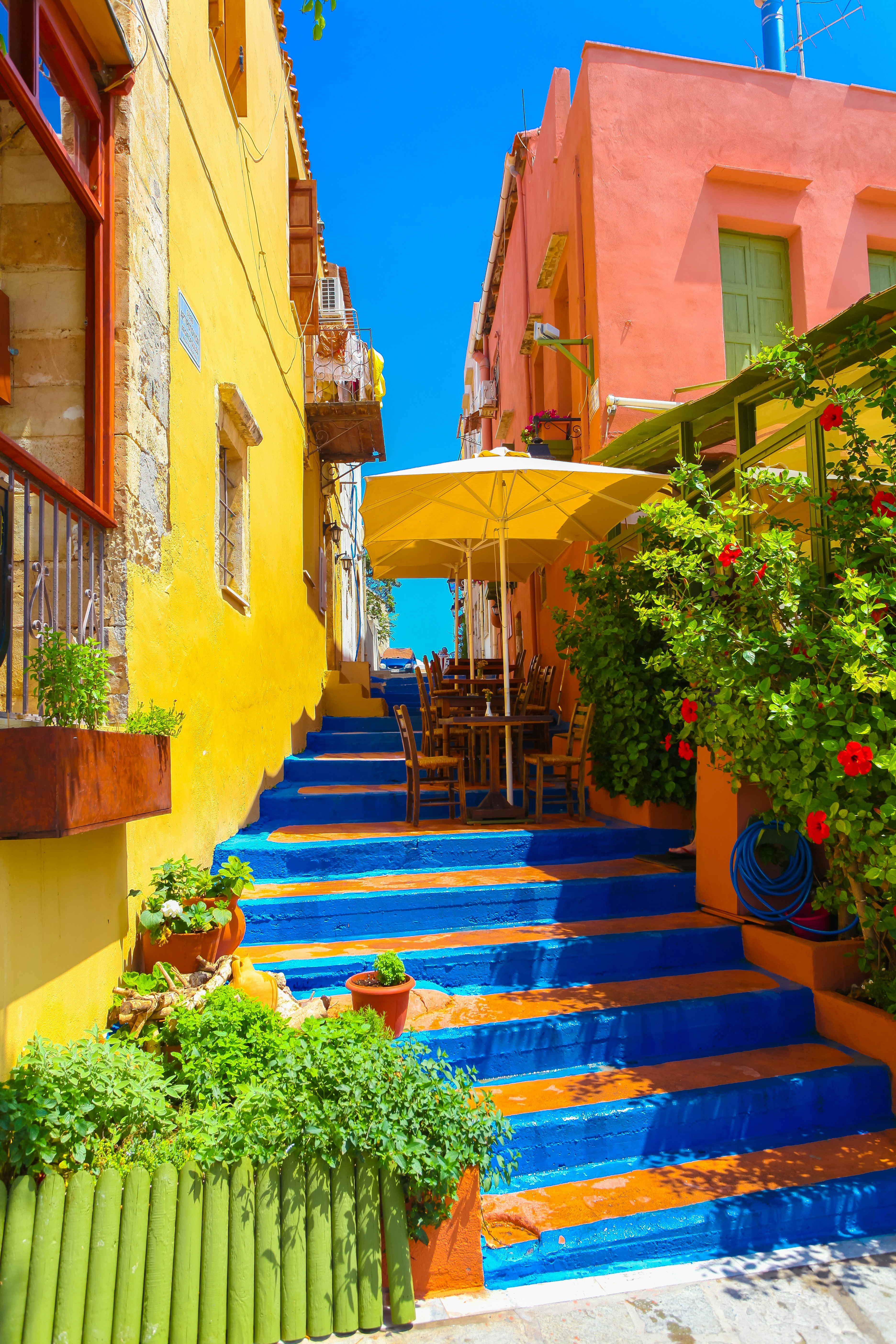 Colorful steps between houses lead up to an open air cafe and blue sky