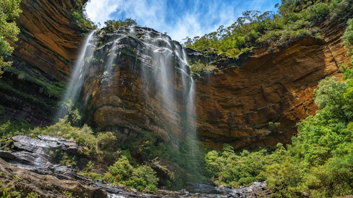 The mist of a waterfall cascading over craggy rocks.