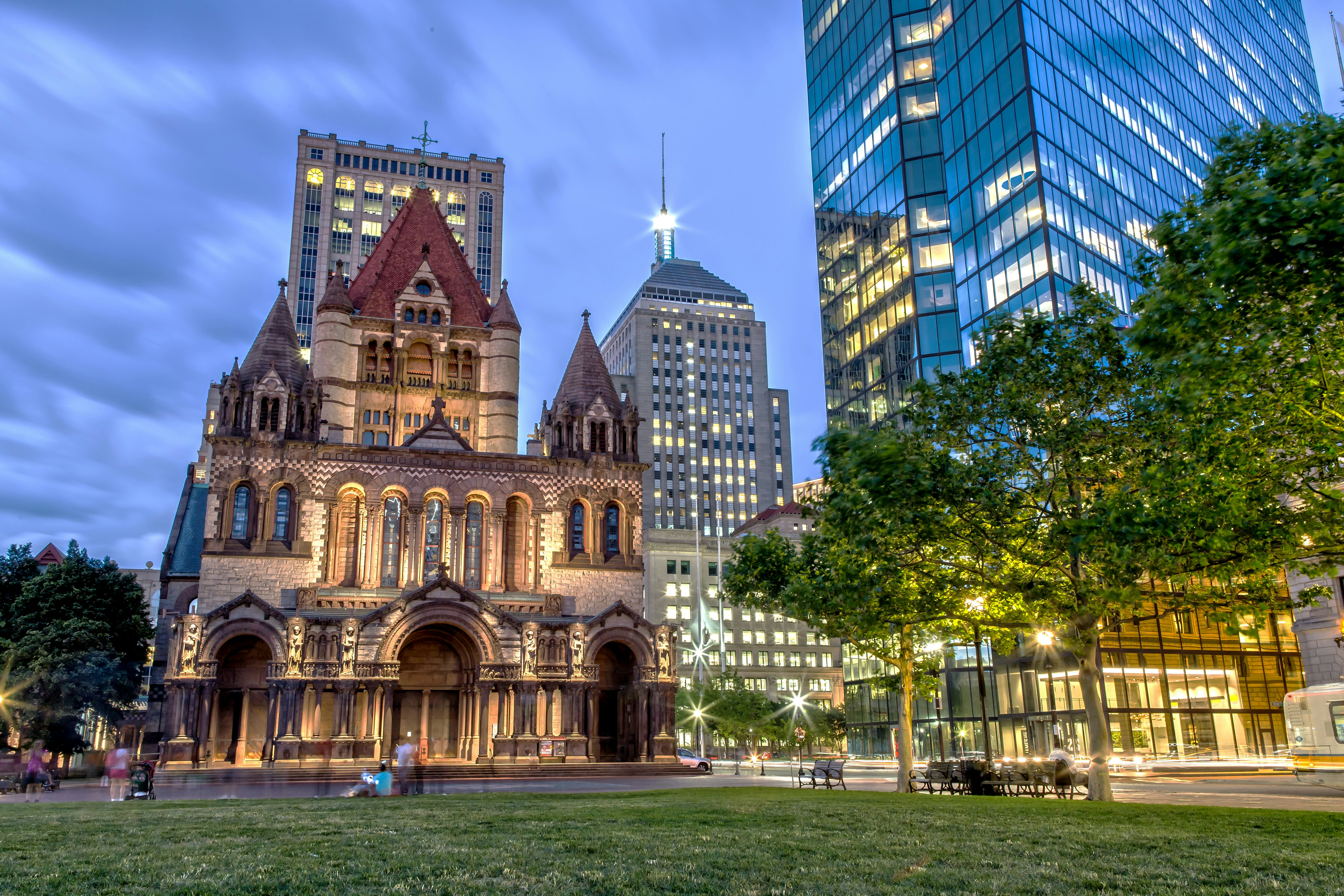 Pedestrians outside Trinity Church in Boston at night