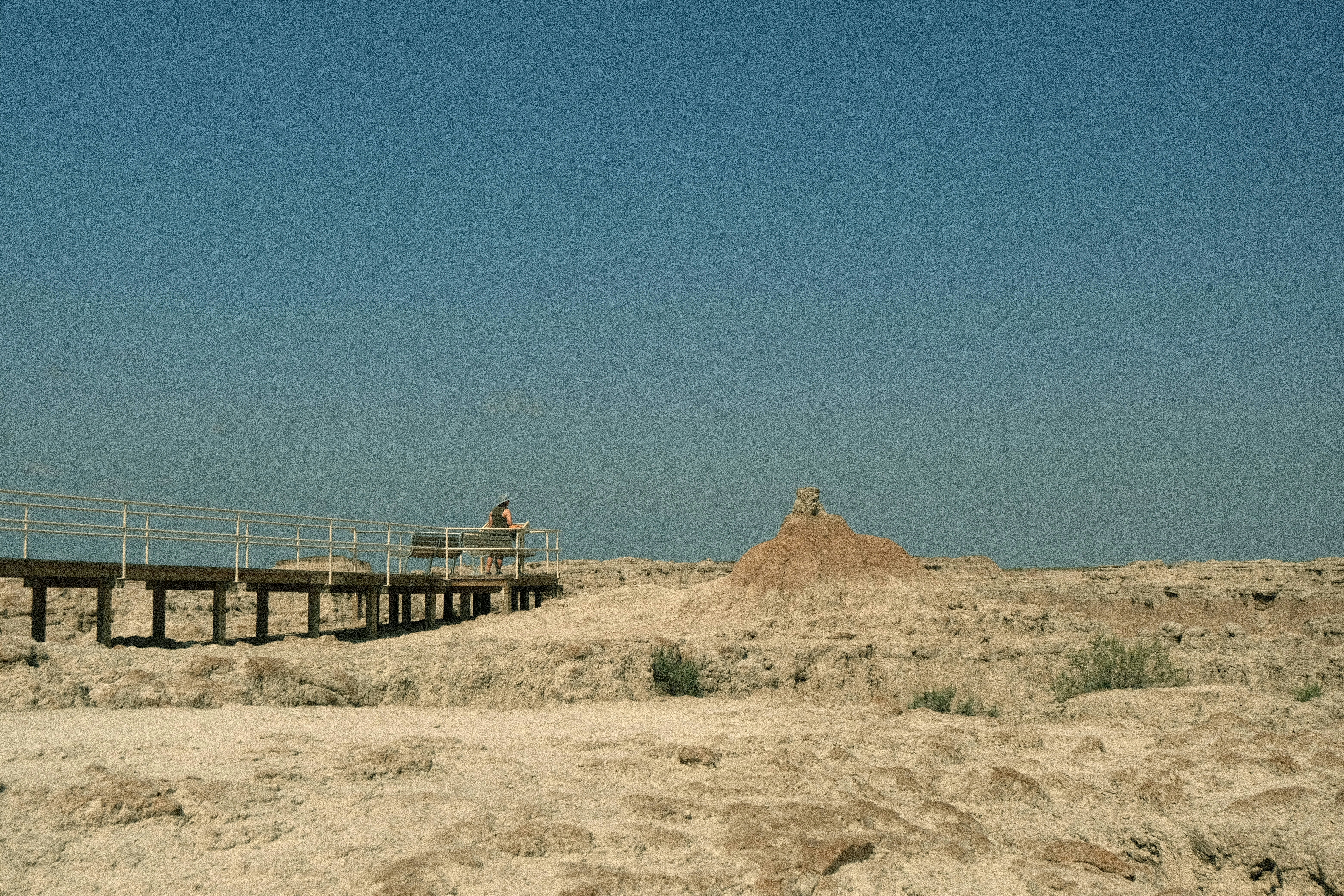 A wheelchair-friendly boardwalk leading across a barren rock landscape on an overcast day.