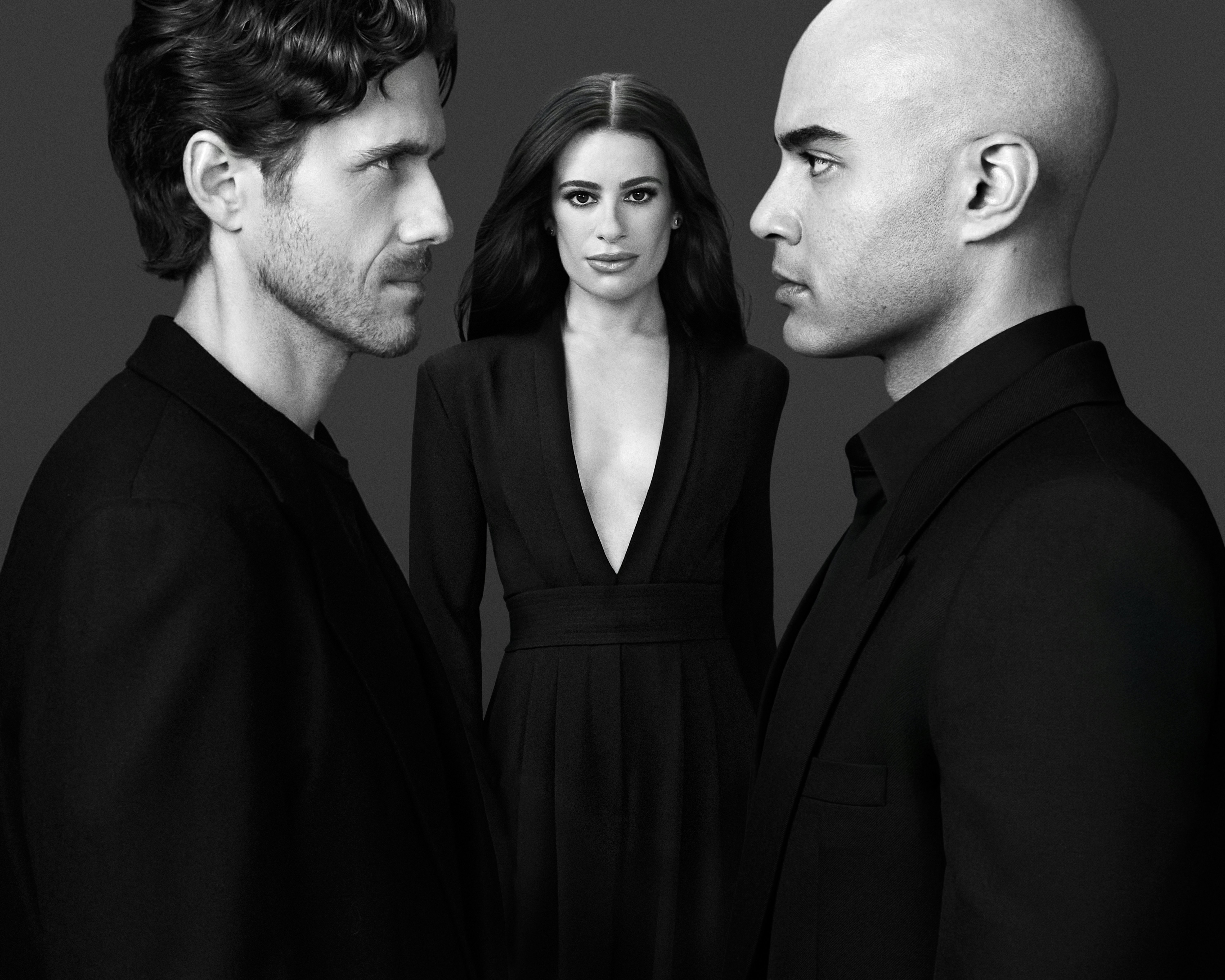 Lea Michele stands between Aaron Tveit and Nicholas Christopher, who face each other, staring