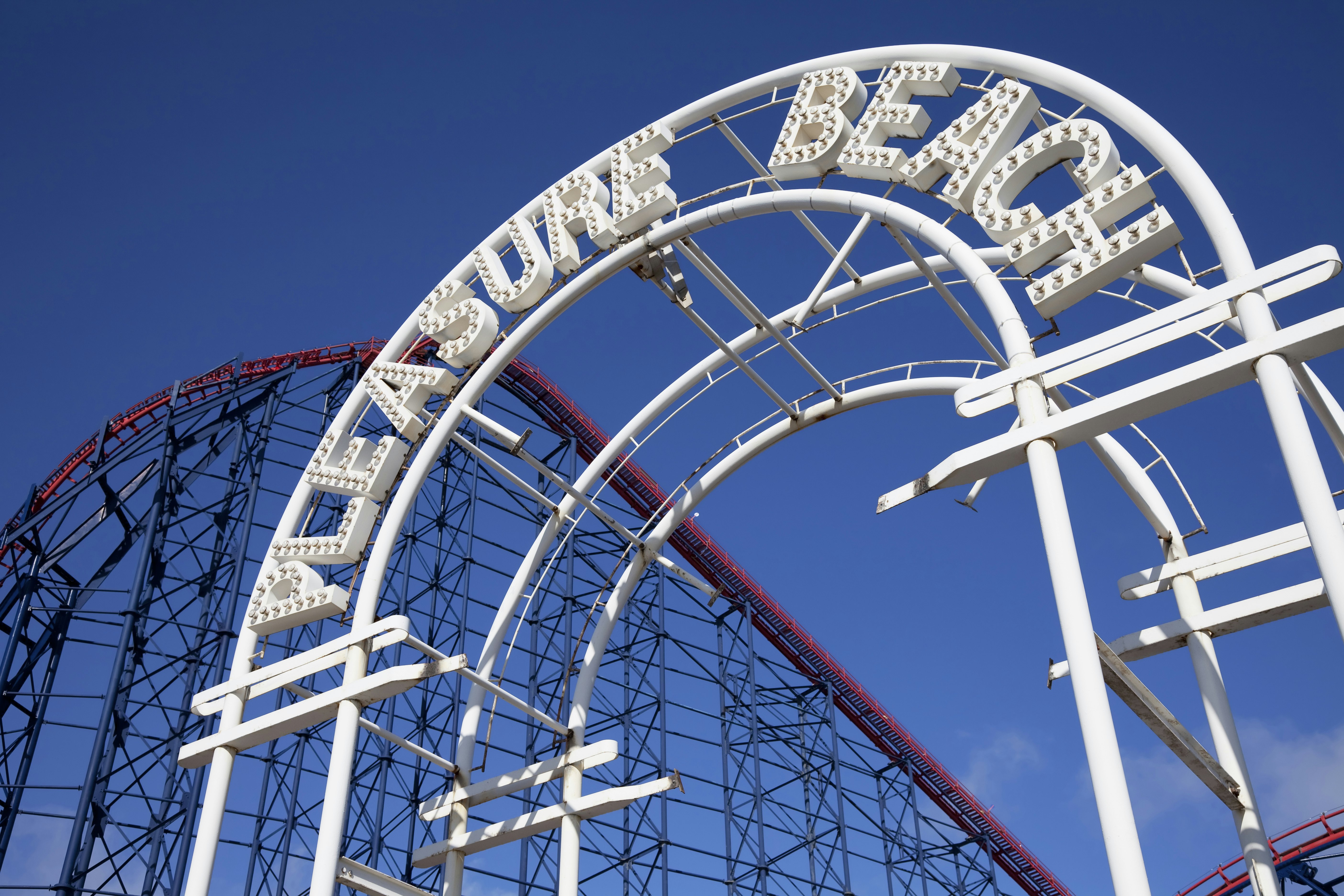 A view of the sign and rollercoast at Blackpool Pleasure Beach, England.