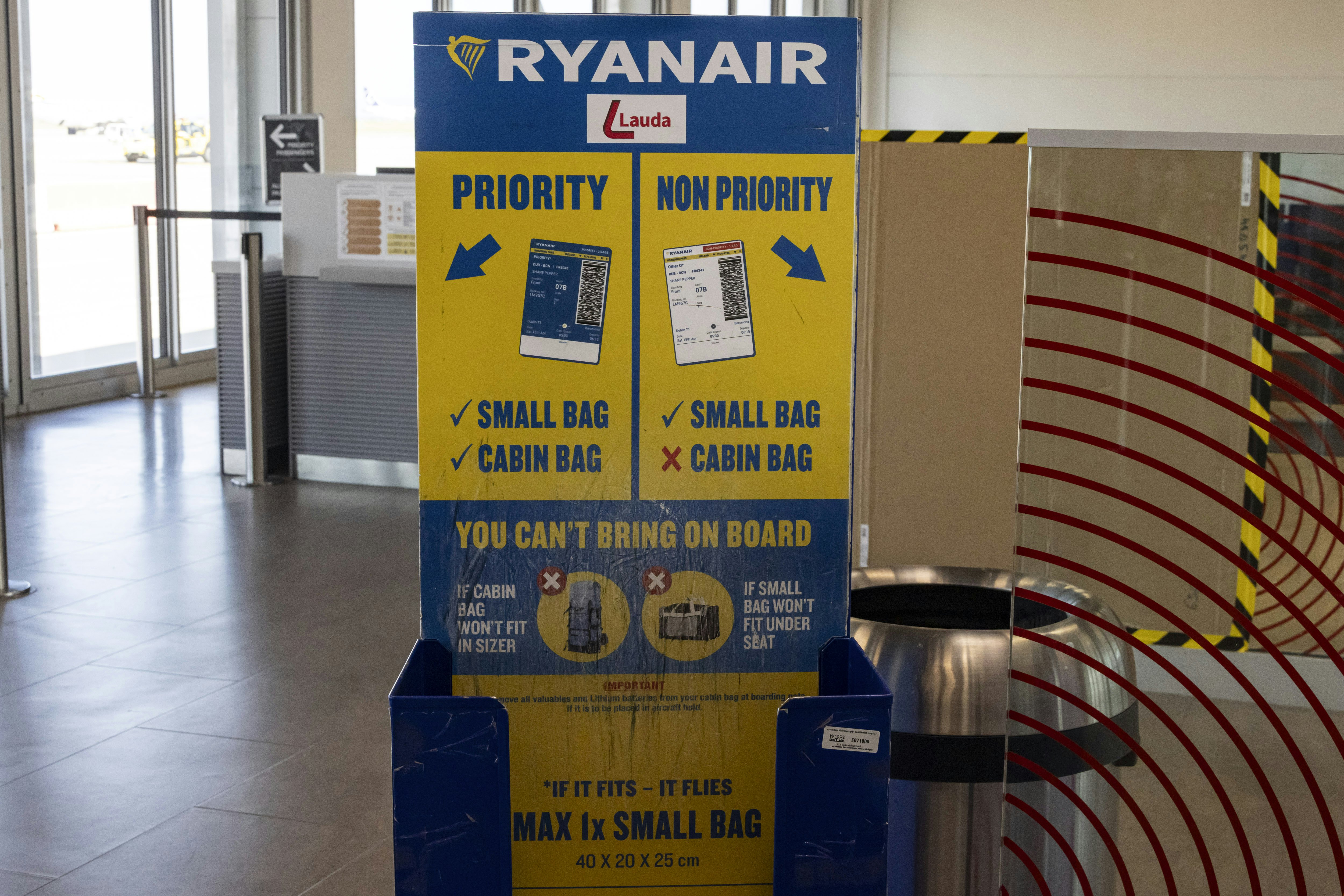A Ryanair cabin baggage measurement cage at an empty boarding gate in an airport.